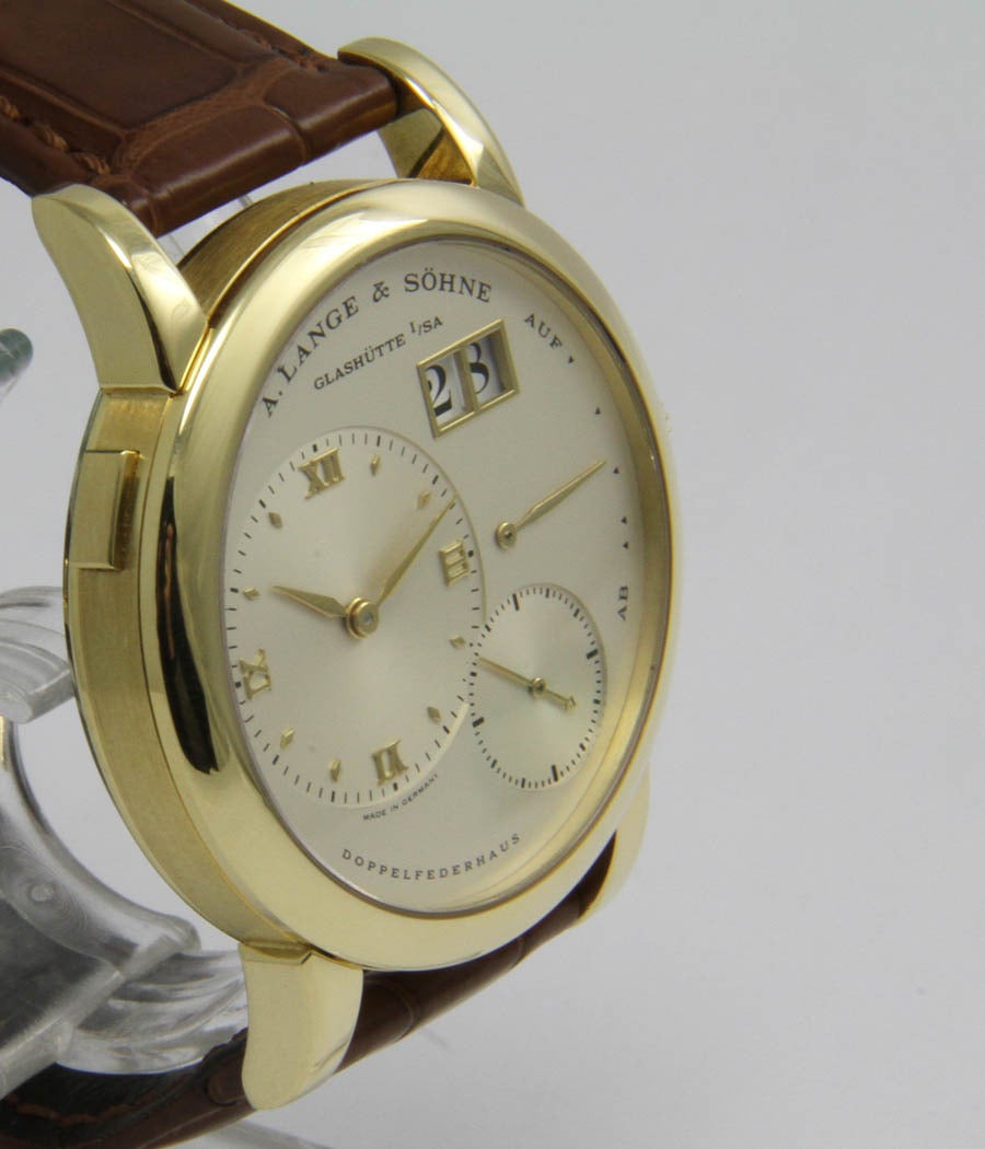 Lange I
Ref. 101.032

Case - Screwed case, yellow-gold, sapphire crystal, 38,5mm
Movement - Caliber 901.0, Doppelfederhaus, manual wind, power reserve, big date.
Bracelet - Lange & Söhne gold buckle

Box and paper, very nice condition.
1995