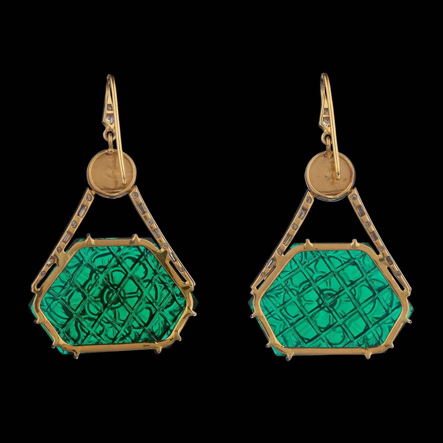 A pair of modern Indian earrings in gold set with diamonds and each with a hexagonal carved green crystal central medallion simulating Mughal carved emeralds. The medallions are suspended each from a single emerald bead drilled in the old style with