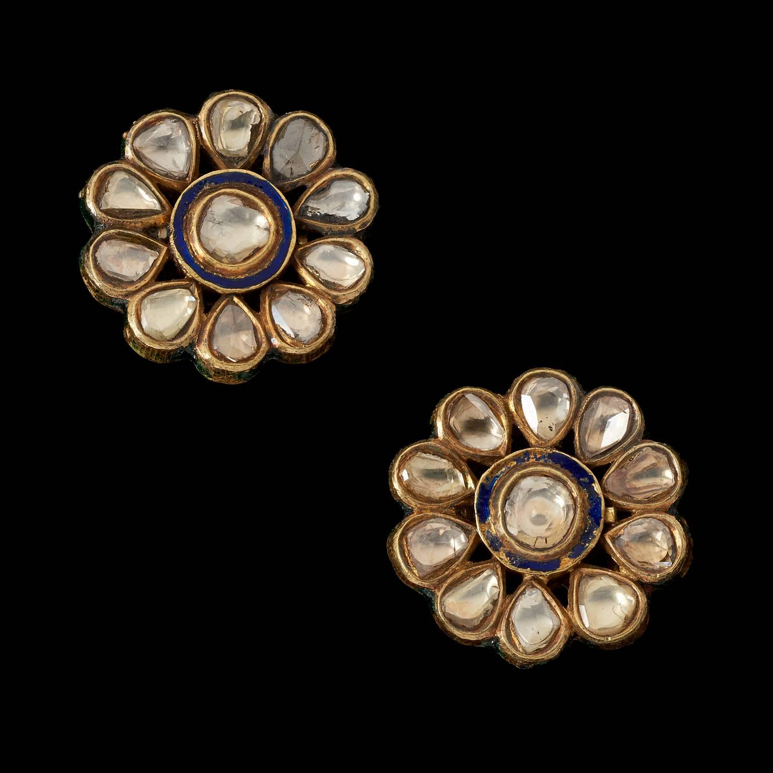 A Pair of Earrings
Mughal, North India
19th century
 
Fabricated from gold, set in kundan (traditional pure gold) technique with diamonds forming a rosette. The back is enamelled.