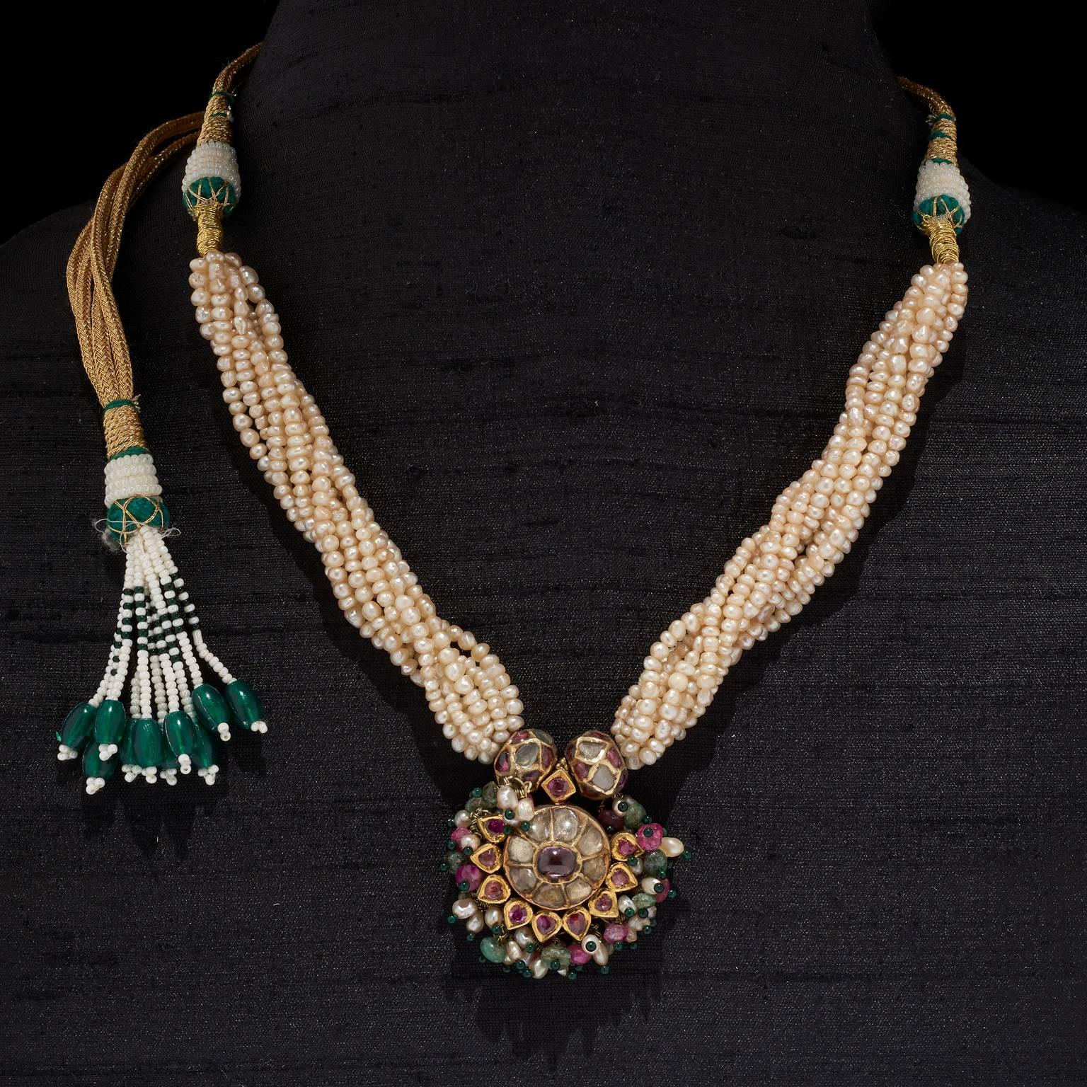 Necklace
Hyderabad, Deccan, India
18th Century

Fabricated from gold the centre piece in 'tanmani' style is kundan (traditional pure gold setting) set with diamonds and rubies with a cluster of pearls, emerald and ruby beads on the fringe.