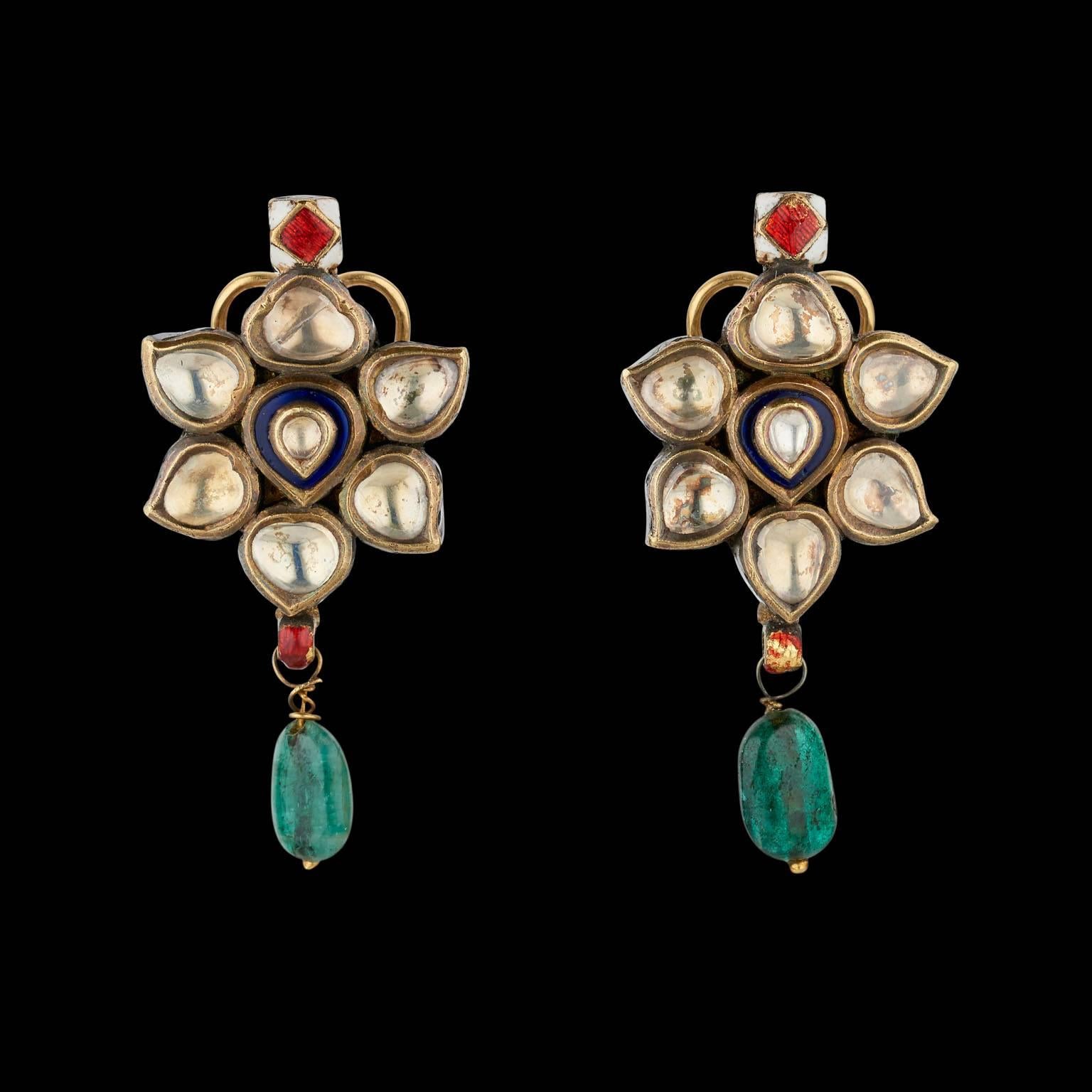 A Pair of Earrings
Rajasthan, North India
19th Century

Fabricated from gold, set in kundan (traditional pure gold setting) technique with white sapphires, each suspended with an emerald bead. The reverse is enamelled.
