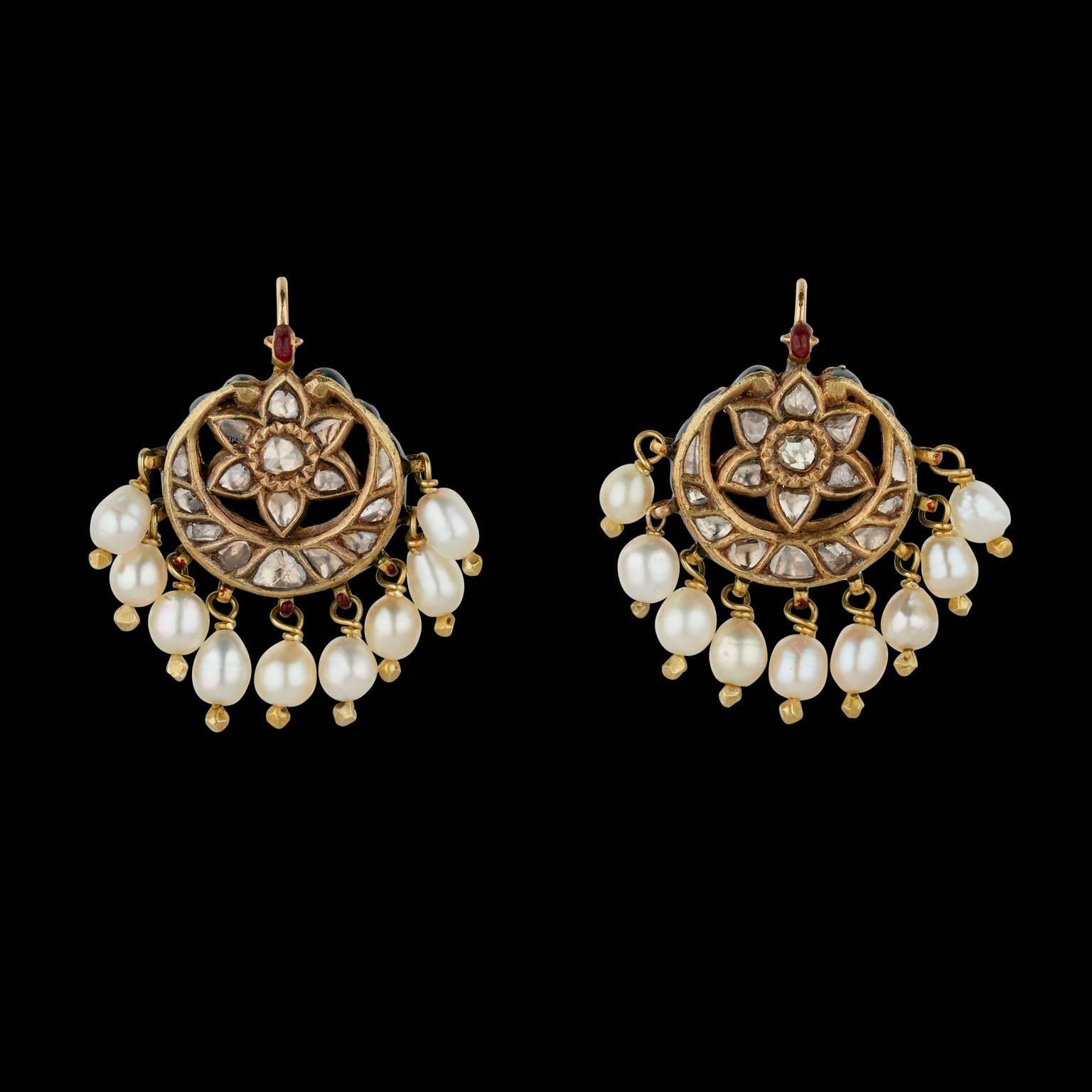 A Pair of Earrings
Mughal, North India
Early 19th Century

Fabricated from gold and set in kundan (traditional pure gold setting) technique with diamonds, strung with a fringe of nine natural pearls. The reverse is enamelled.