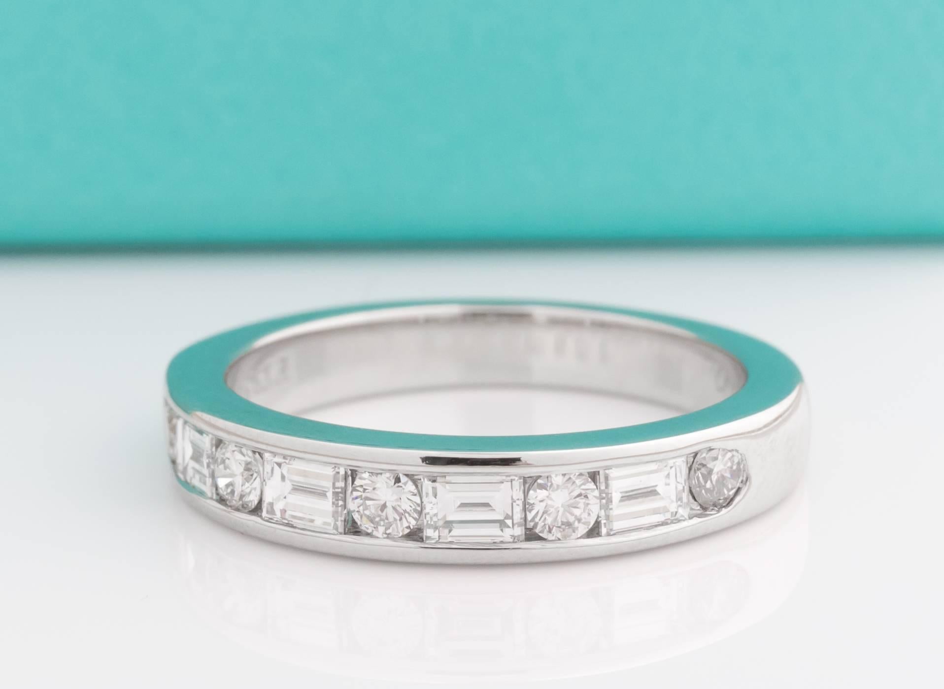 Tiffany & Co channel-set band ring with a half circle of round brilliant diamonds and baguette diamonds placed in alternating pattern. All diamonds are F color and VS clarity. Round diamonds weigh 0.21cts total and baguettes weigh 0.45cts total. The
