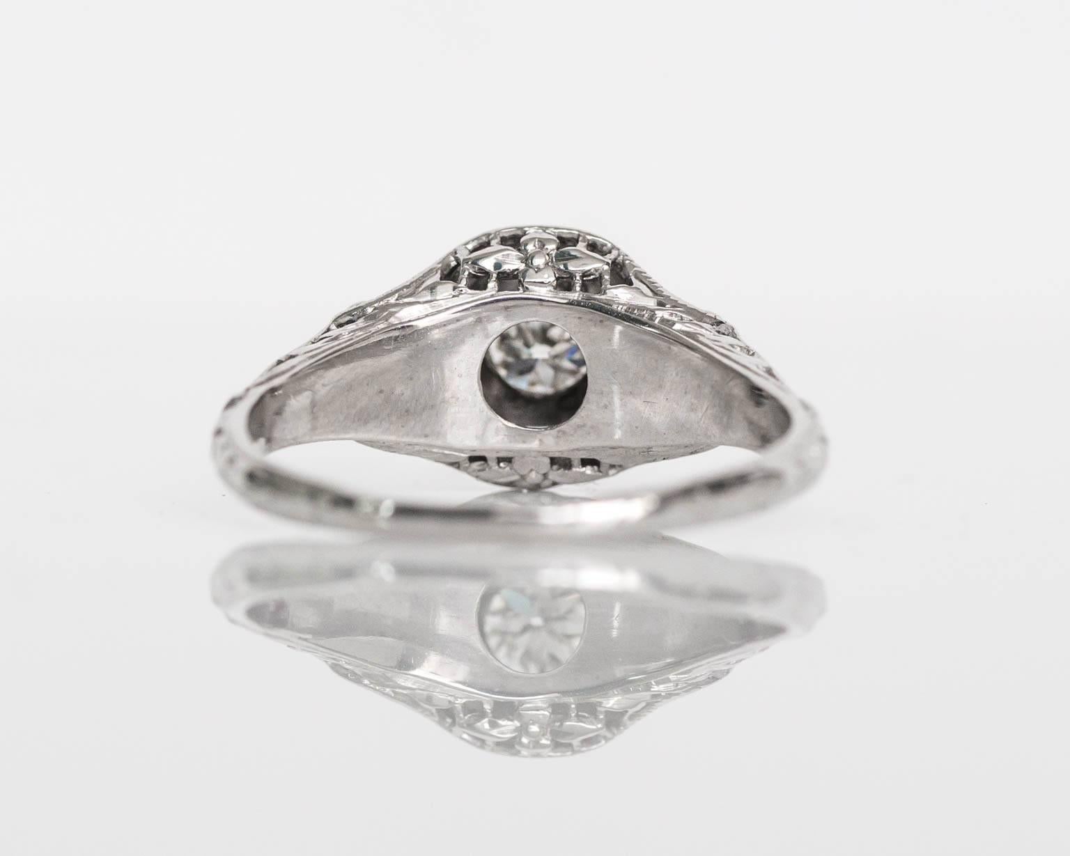 Here we have an absolutely spectacular unique filigree ring from the early 1910's. The center diamond is an absolutely delightful old european cut with great fire and brilliance. It is set in a smooth bezel setting style and surrounded by some of