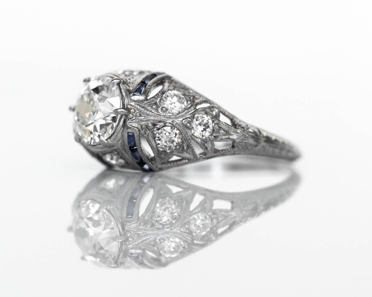 1920s Platinum Art Deco 1.03 carat Diamond Engagement Ring with Side Stones & Natural Sapphires

Item Details: 
Ring Size: 7
Metal Type: Platinum
Weight: 3.3 grams

Center Diamond Details:
Shape: Round 
Carat Weight: 1.03 carat
Color: I