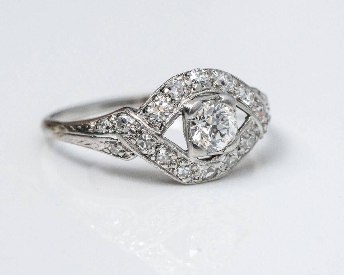 1920s Art Deco GIA .34 Carat Diamond Engagement Ring. This stunning ring has a French origin. Platinum crafted, it features a stunning crossover design with rows of diamonds intertwining with each other. The center holds a gorgeous GIA-certified