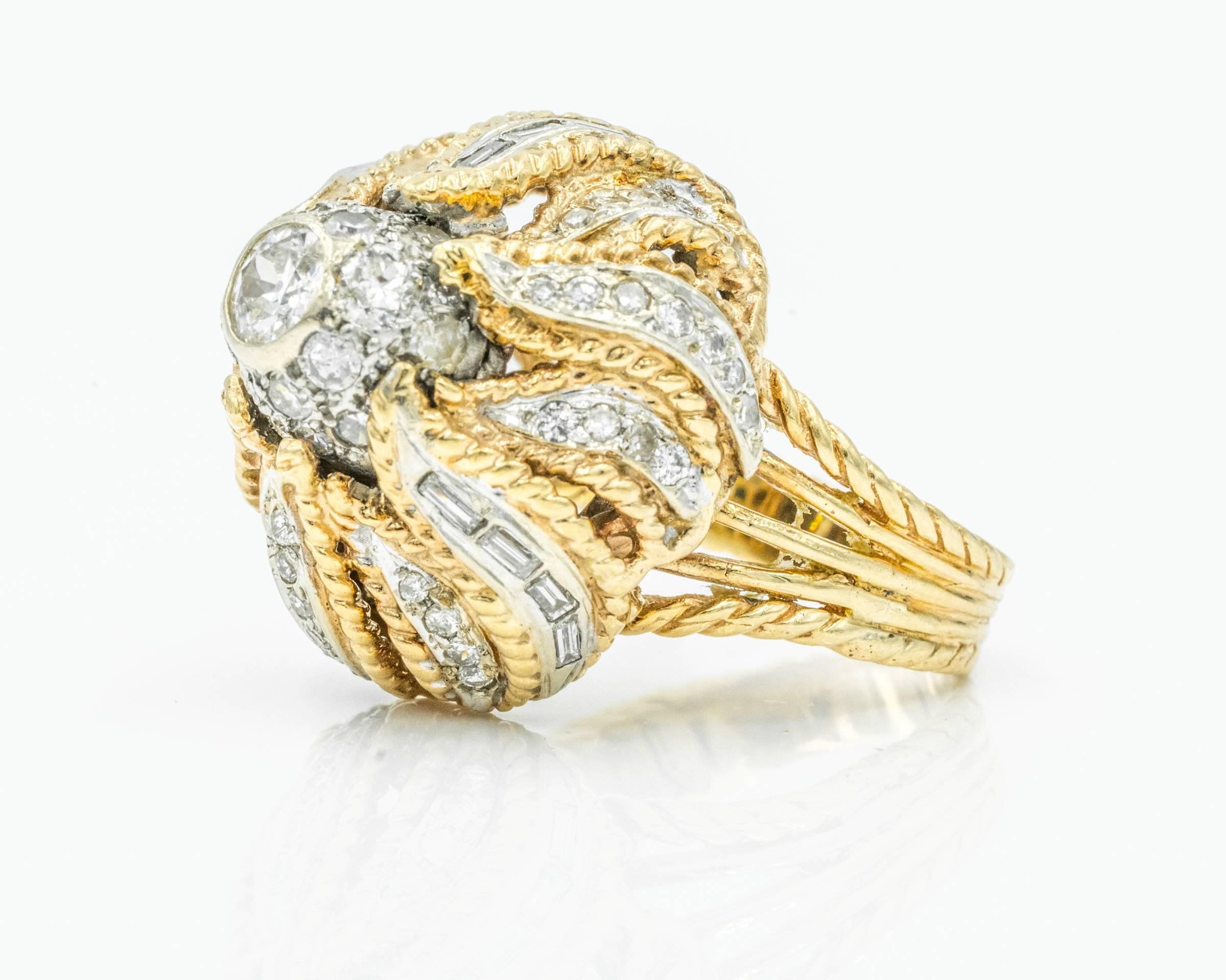 1960s Diamond Cocktail Ring with Floral Head Design, Ornate appearance. Crafted in 18 karat Yellow Gold and Platinum (where diamonds are set). Thick shank made of 5 rows of 18 karat gold that taper down, has a braided weave appearance. 
Diamond in