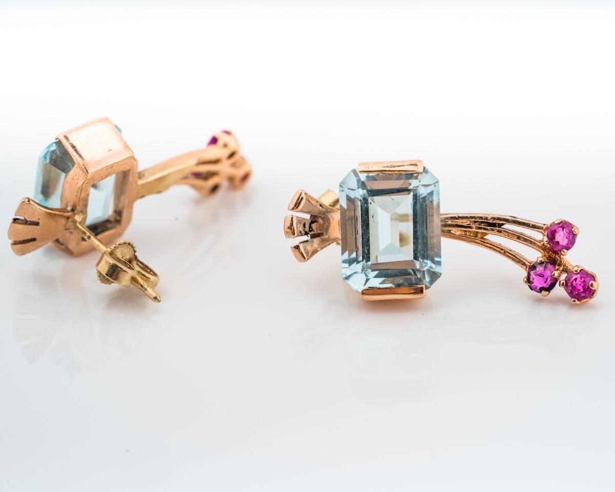 14 Karat Rose Gold Drop Earrings
1950s 
Featuring Aquamarine and Accent Rubies (both natural gemstones)
0.20 carats total Rubies
Aquamarine weighs 8.4mm x 10.4mm 
Elegant Design 
