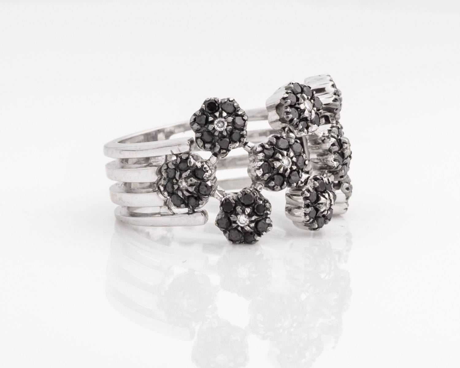 High Quality 18 Karat White Gold Diamond Ring 
Features Black and White Diamonds; all black diamonds are AAA quality
Ring Size 7.5 (can be resized)
Italian Made 
2.5 mm thick white gold bezel frame 
Floral Design; flowers are arranged in a
