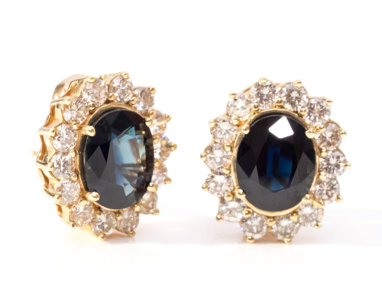 Deep Blue Oval Sapphires
Elegant Design with Ultra Shine and Color Play
Gemstones are 10 mm x 8 mm and weigh about 2 carats each
Halo of Diamonds weigh approximately 3 carats total 
Small Gallery visible Underneath the Gemstones 
Each Earring has