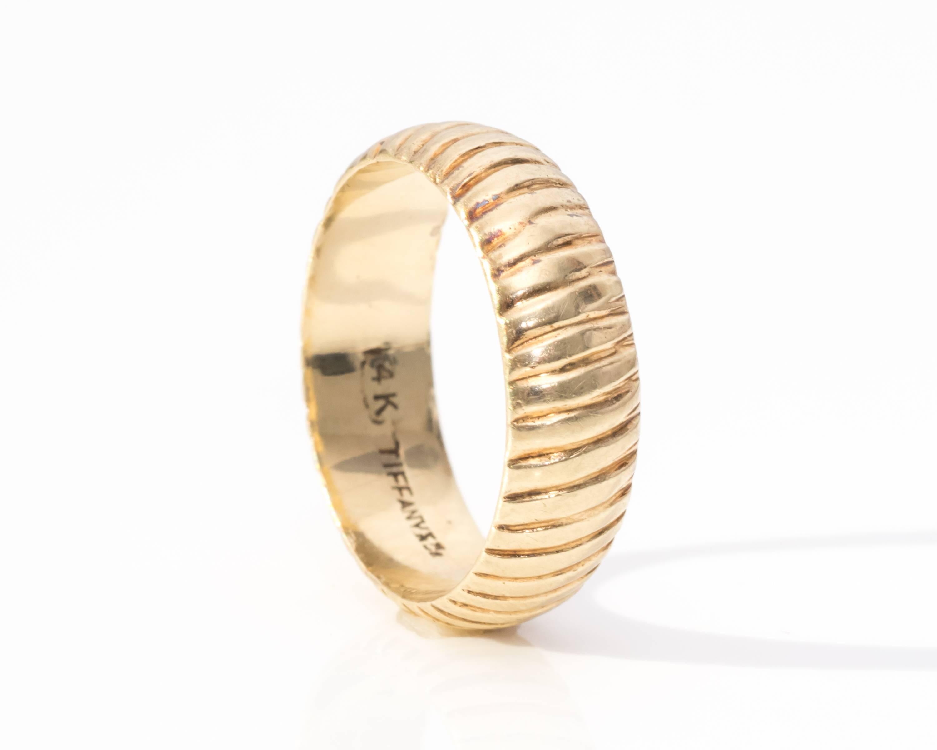 1970s Tiffany & Co. Yellow Gold Ring Band
Fits Ring Size 5.5 (cannot be resized, but can be worn on any finger)
Features a Unique Ribbed Pattern Around the Band
Hallmarked 