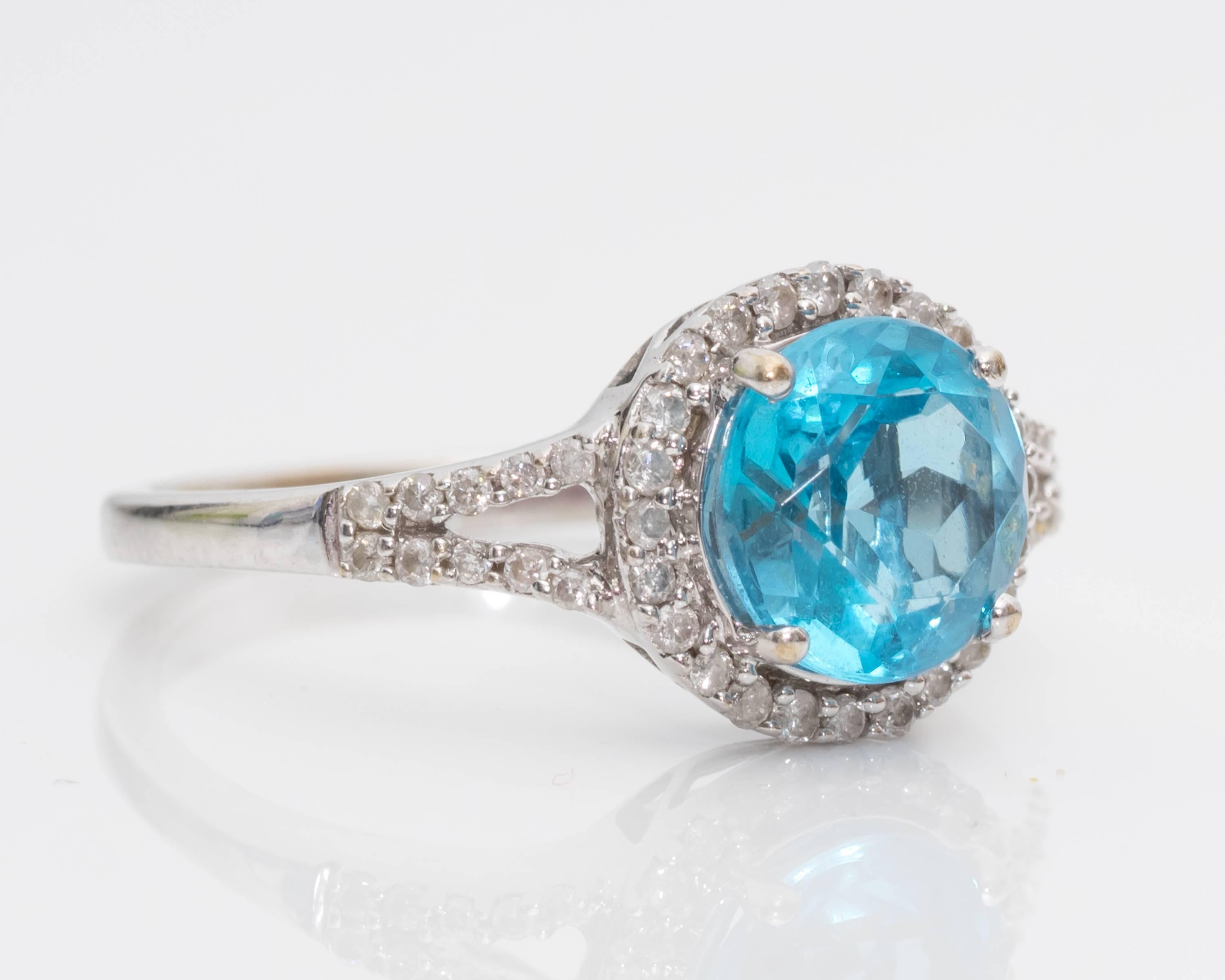 Blue Topaz and Diamond Halo Ring - 14 Karat White Gold, Blue Topaz, Diamonds

The 1.0 carat round Blue Topaz is surrounded by a Diamond Halo. The split shoulders are diamond encrusted. The setting has an open gallery which amplifies the brilliance