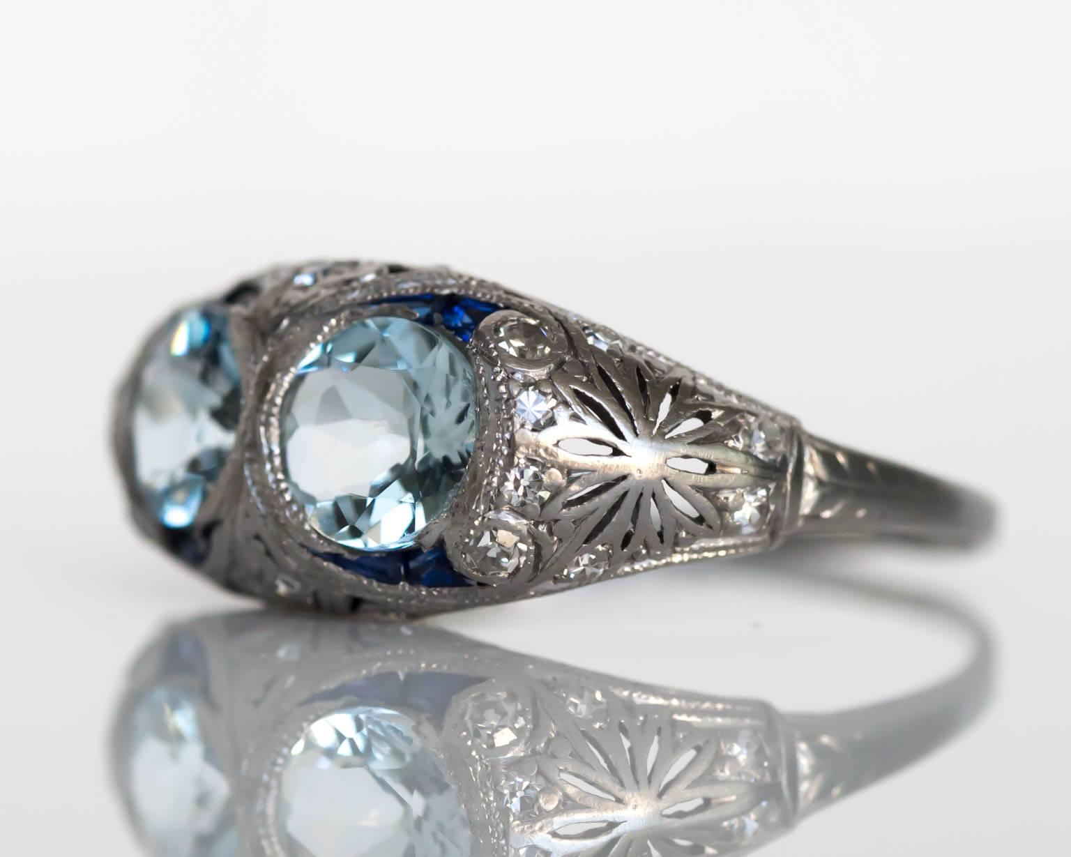 Item Details: 
Ring Size: 9
Metal Type: Platinum
Weight: 4.6 grams

Color Center Stone Details: 
Type: Aquamarine, Natural (2) 
Shape: Round
Carat Weigh: .75 carat each (1.50 carat, total weight)
Color: Fine Blue
Clarity: VS

Diamond Details:
Carat