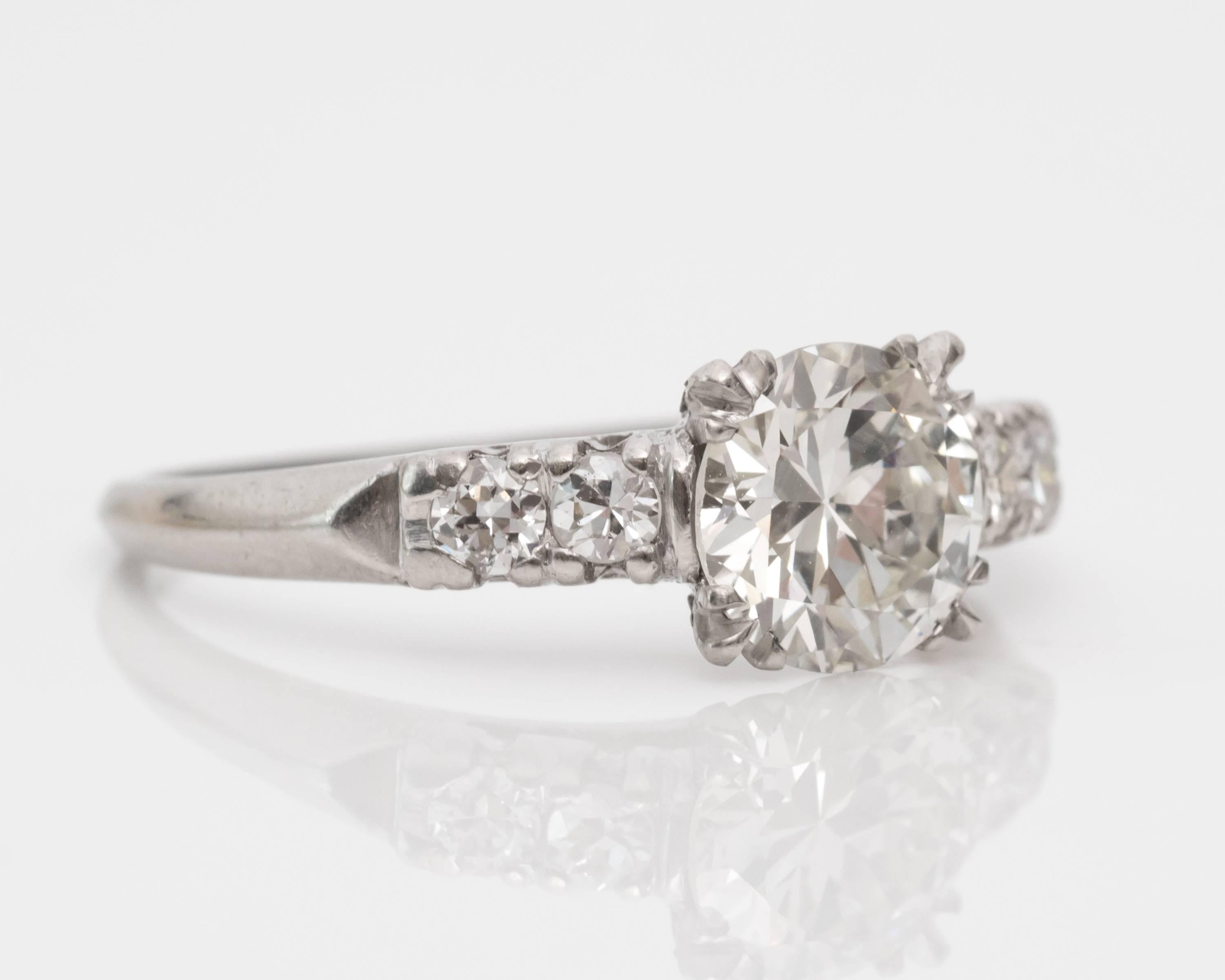 1935 Art Deco Diamond Engagement Ring Featuring GIA-Certified Center Stone weighing 0.99 Carats
Set in Four Triple-Fishtail Prongs 
Tapers to a Smooth Platinum Shank that features Four Accent Diamonds.
Simple Sleek Design with All Attention on the