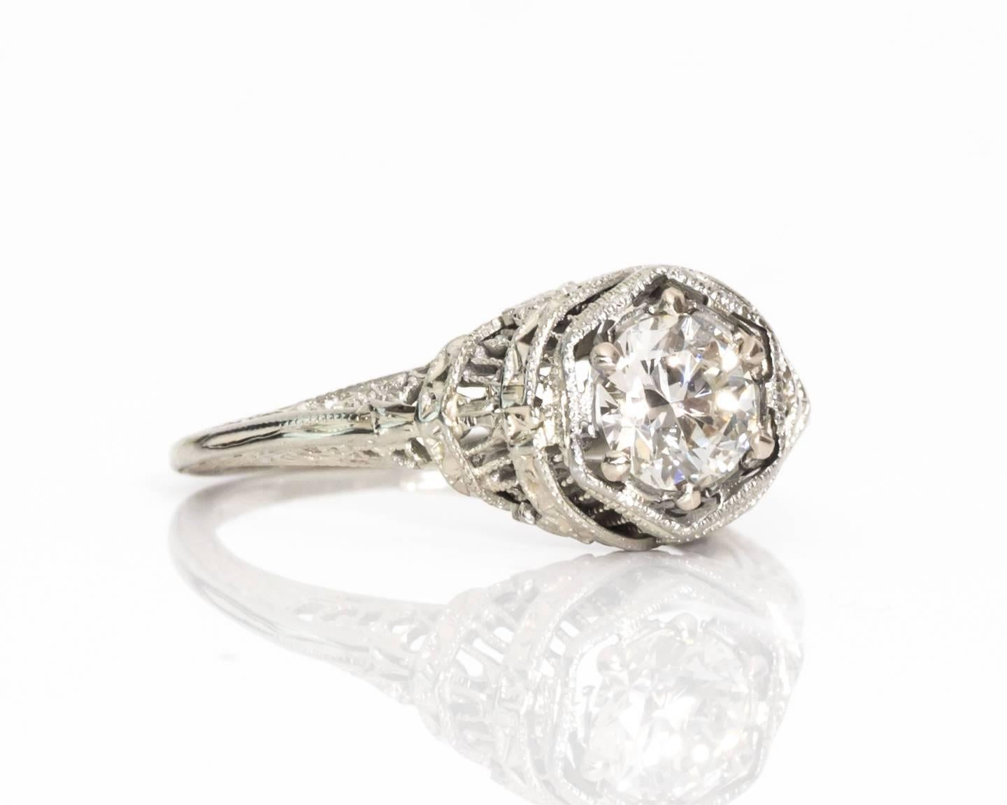 A ring almost as fanciful as the wedding cake! The intricate side profile of this piece includes draping and filigree etchings to the finest degree of craftsmanship. The solitaire ring has a GIA certified diamond set in a six-prong frame with