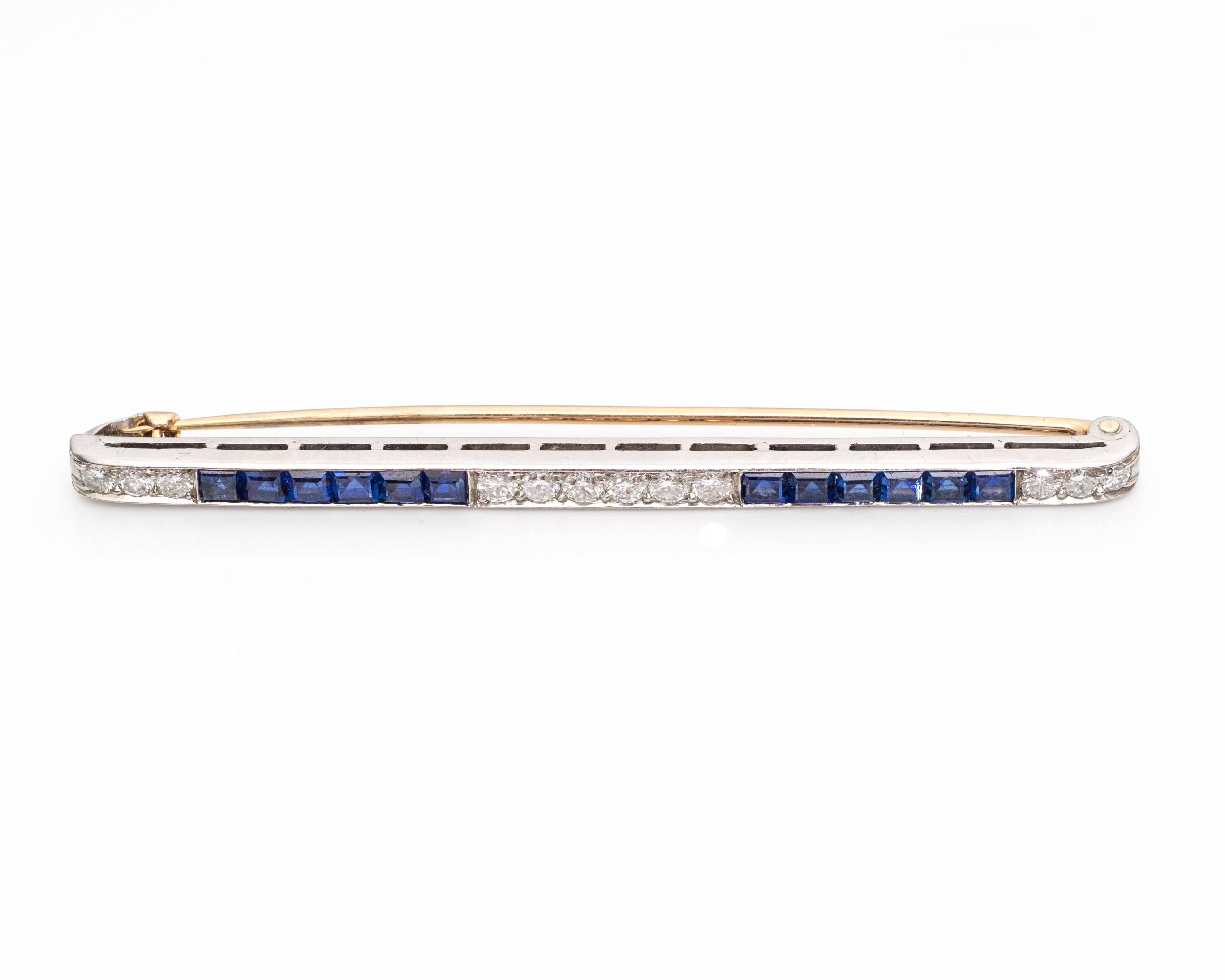 1940s Retro Tiffany & Co. Diamond Platinum Bar Pin Brooch. Features 12 round brilliant diamonds and 12 princess cut blue sapphires along the frame of the bar. A row of 6 diamonds is centered on the pin, flanked by two rows of 6 sapphires, 1 row on