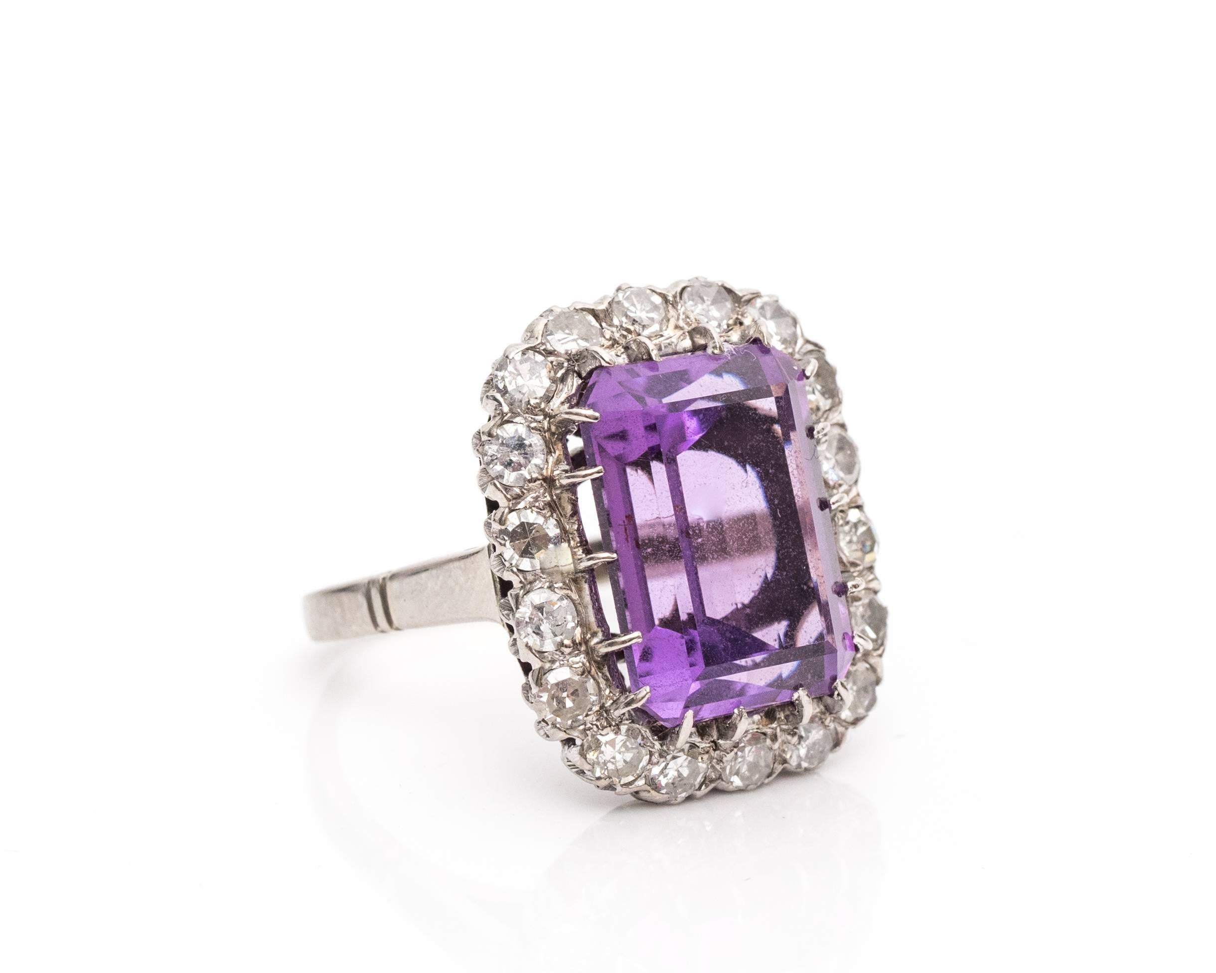 A drop dead gorgeous ring! This piece embodies the 1940s due to the larger-than-life gemstones and design. This is most definitely a statement piece!

The center features an ornate amethyst as a royal purple color, emerald shape, and total of 5