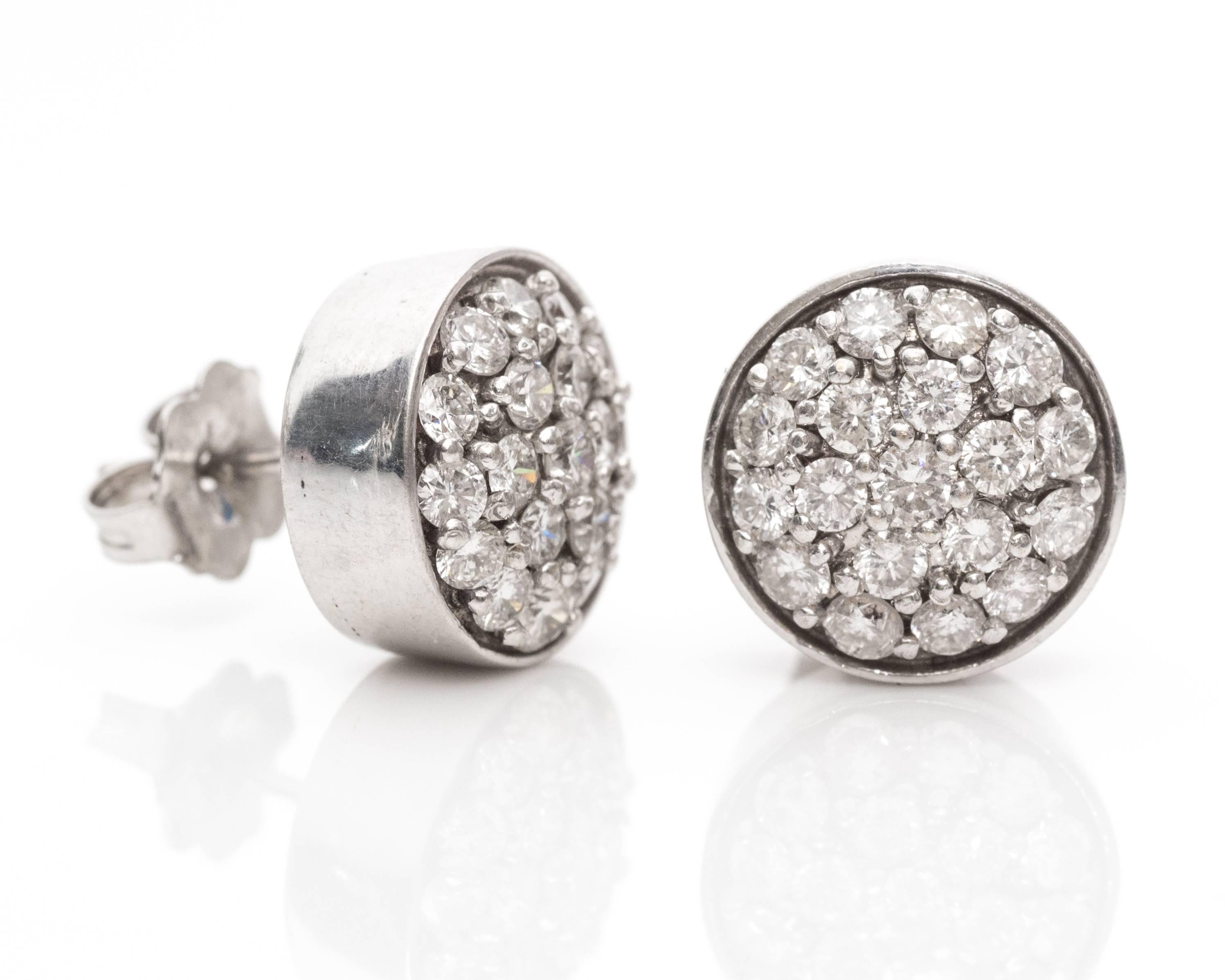 Each earring has 19 Diamonds prong set within a round bezel frame. The setting creates the illusion of a 3 ct diamond stud. The earrings are crafted from 14k White Gold. 

These earrings measure 1cm across. They are hallmarked TYCOON 14K.

The metal