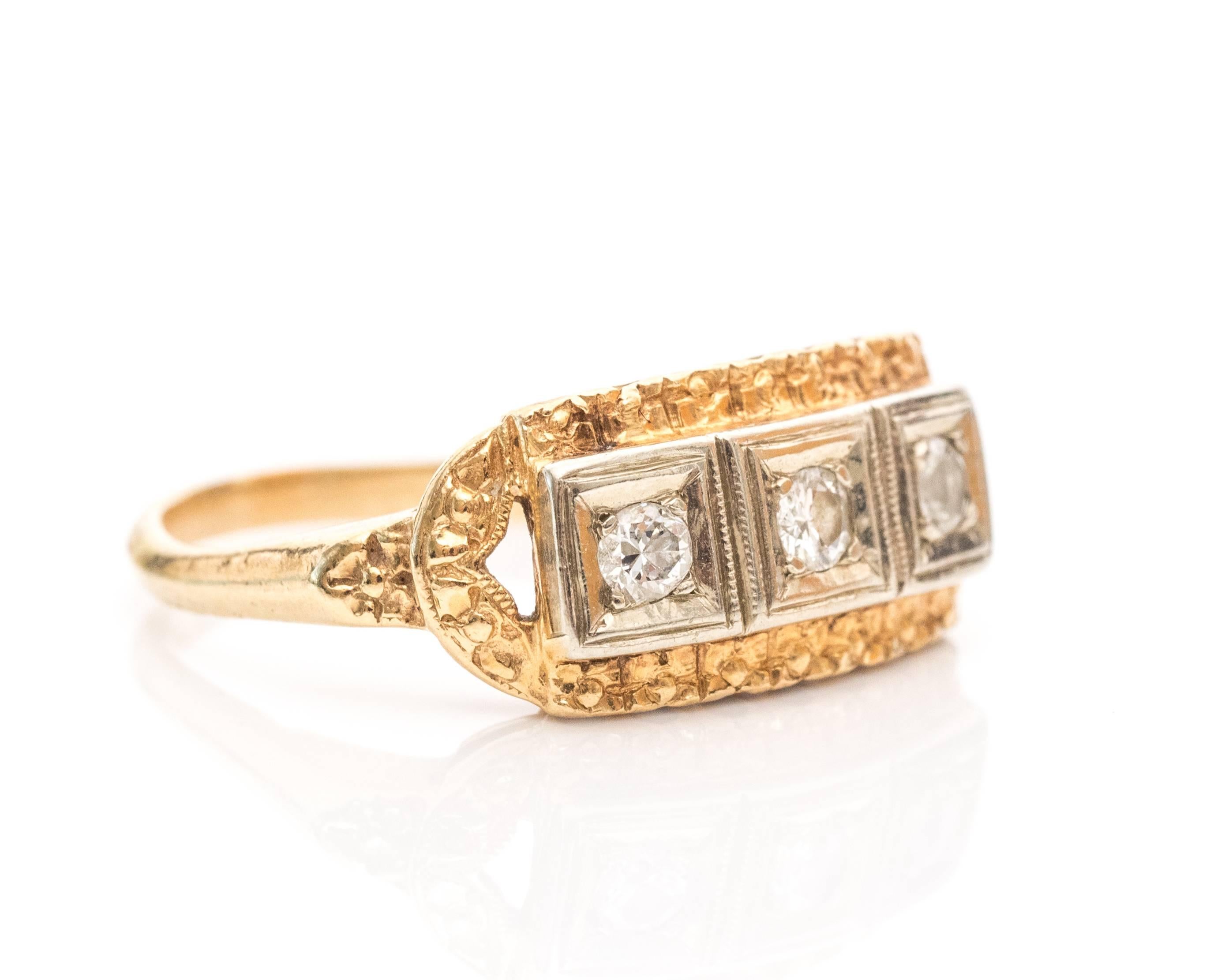 1920 Art Deco Three-Stone Diamond Two-Tone 14 Karat Gold Ring. This piece has three diamonds placed in a 14k white gold center. The white gold has milgrain patterns between each individual square shaped bezel frame. The diamonds total to .03 carats.