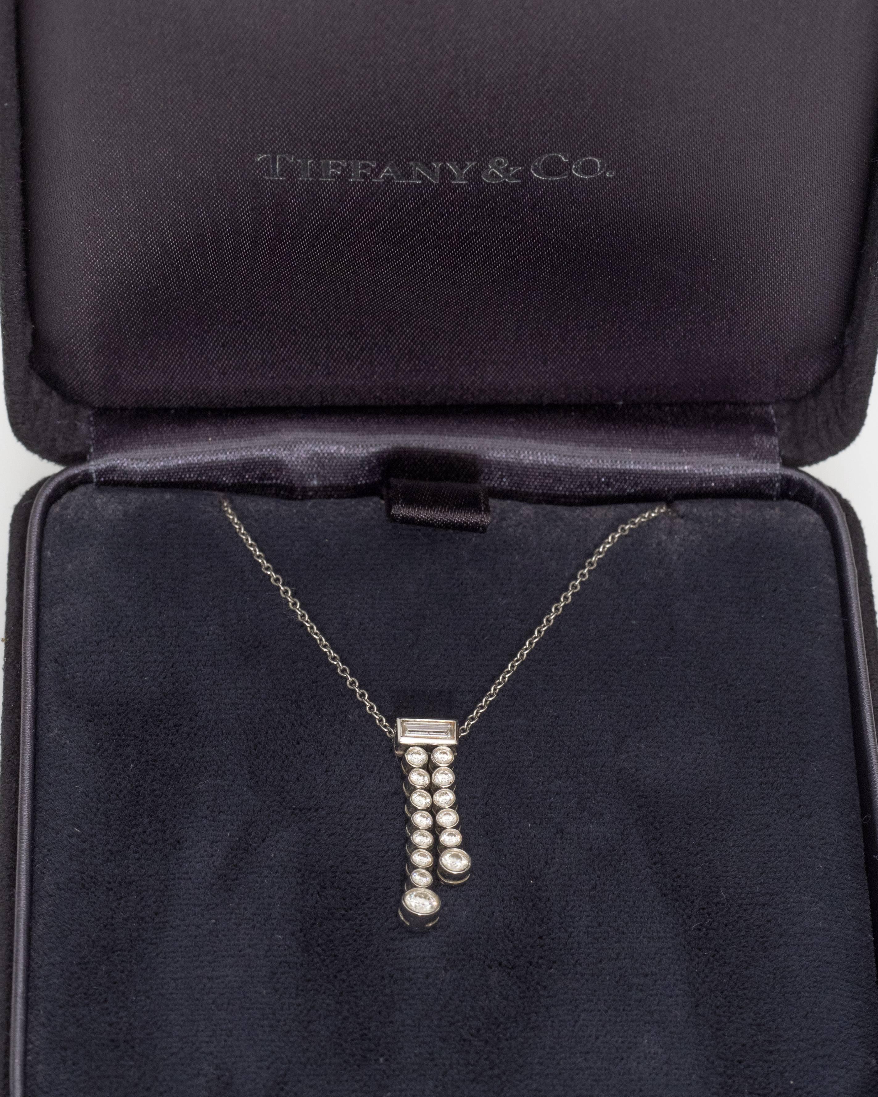 This Tiffany & Co. necklace is part of the jazz collection. The pendant has two strands of diamonds next to each other - one with eight diamonds, the other with six. The top of the pendant has a baguette diamond right where the platinum connections