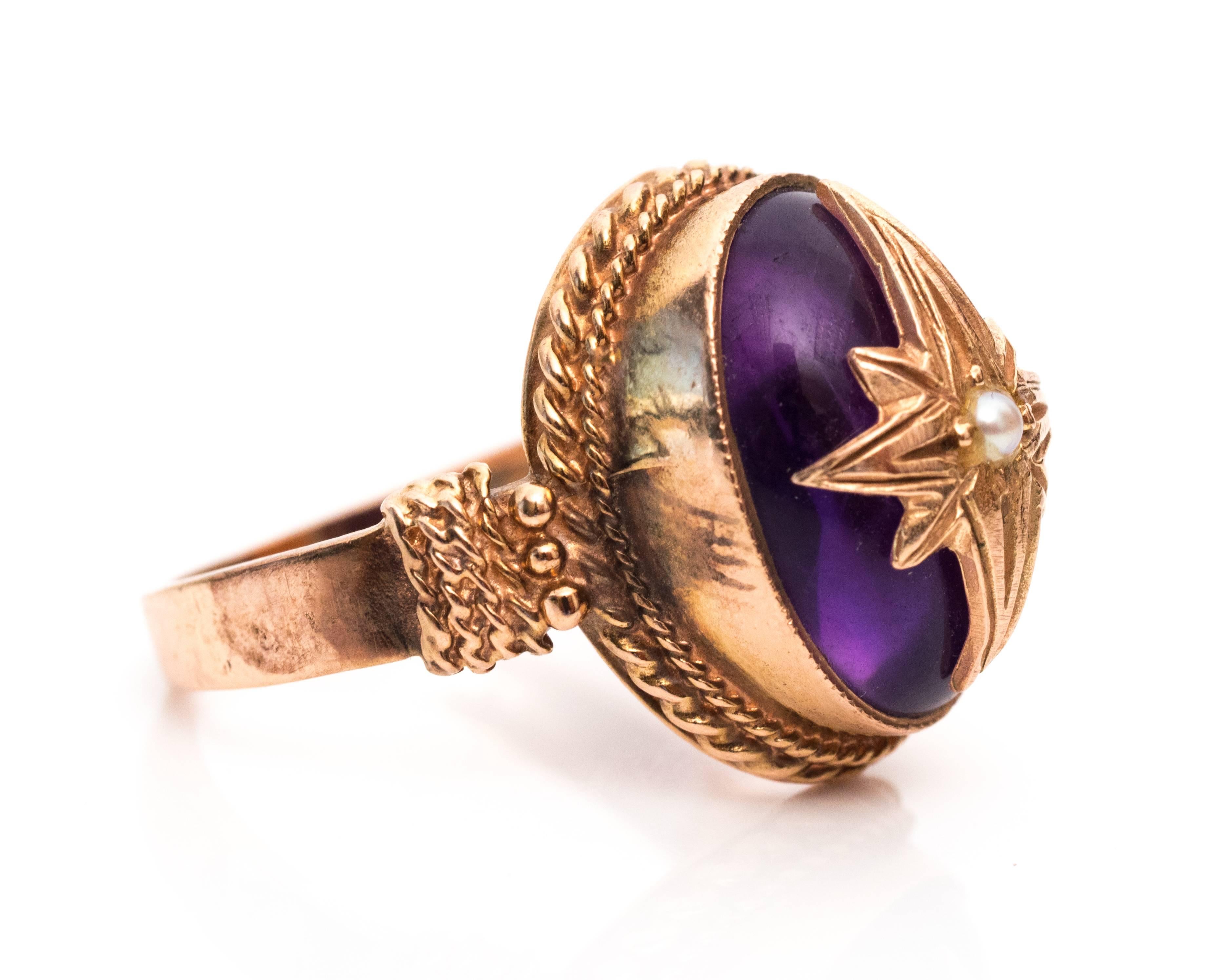 1900s Edwardian Amethyst, Seed Pearl and 9 Karat Rose Gold Ring features a beautiful purple cabachon amethyst. It's a rare hand made piece that would be a lovely add on to your collection. The cabochon amethyst is set in a rose gold bezel frame with