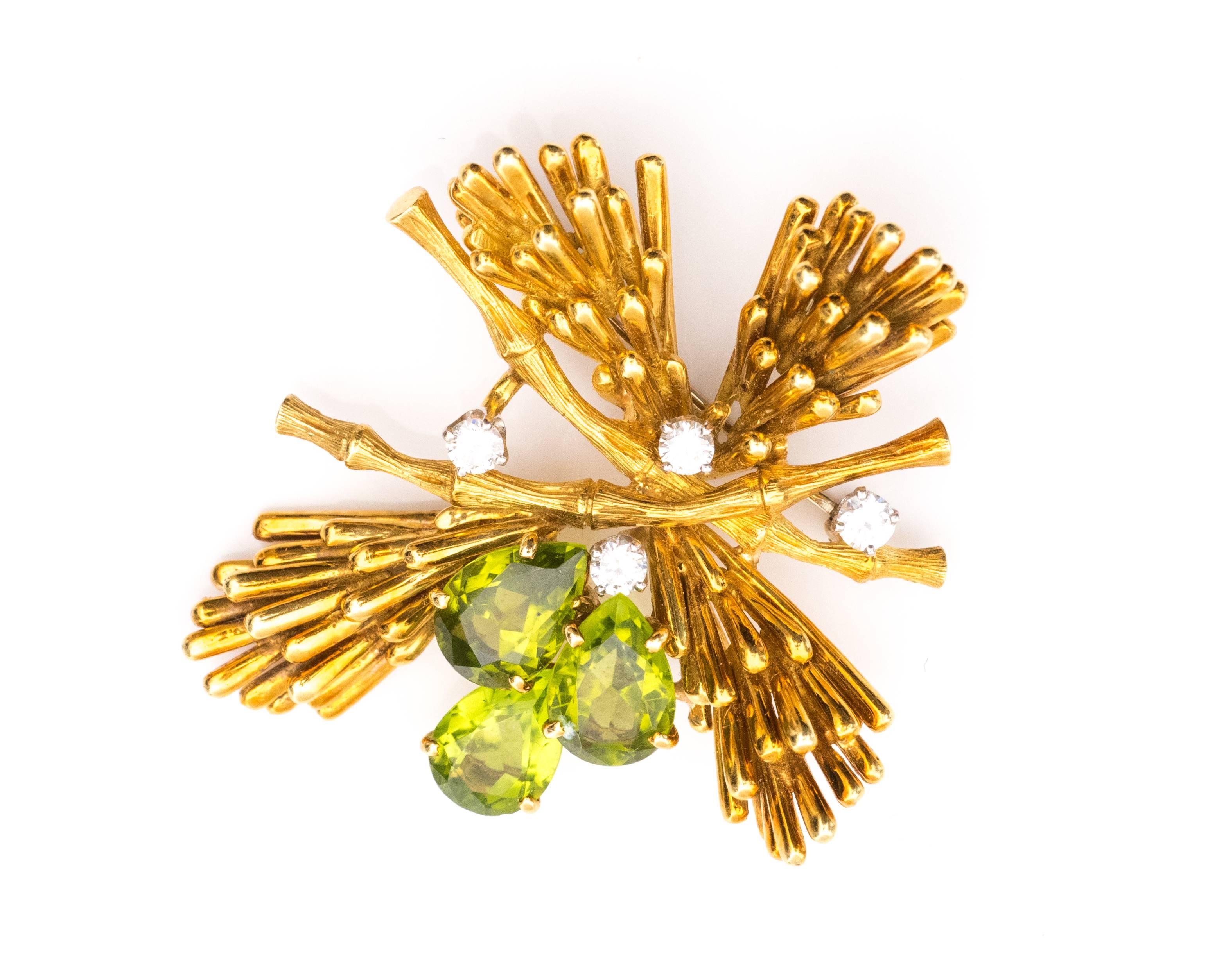 1970s Vintage Raymond Yard Brooch features 18 Karat Yellow Gold, Diamonds and Peridot. It has a White Gold Clasp.

This pin exhibits the designers abstract interpretation of nature. The evergreen branch motif has a bamboo textured stem, spruce leaf