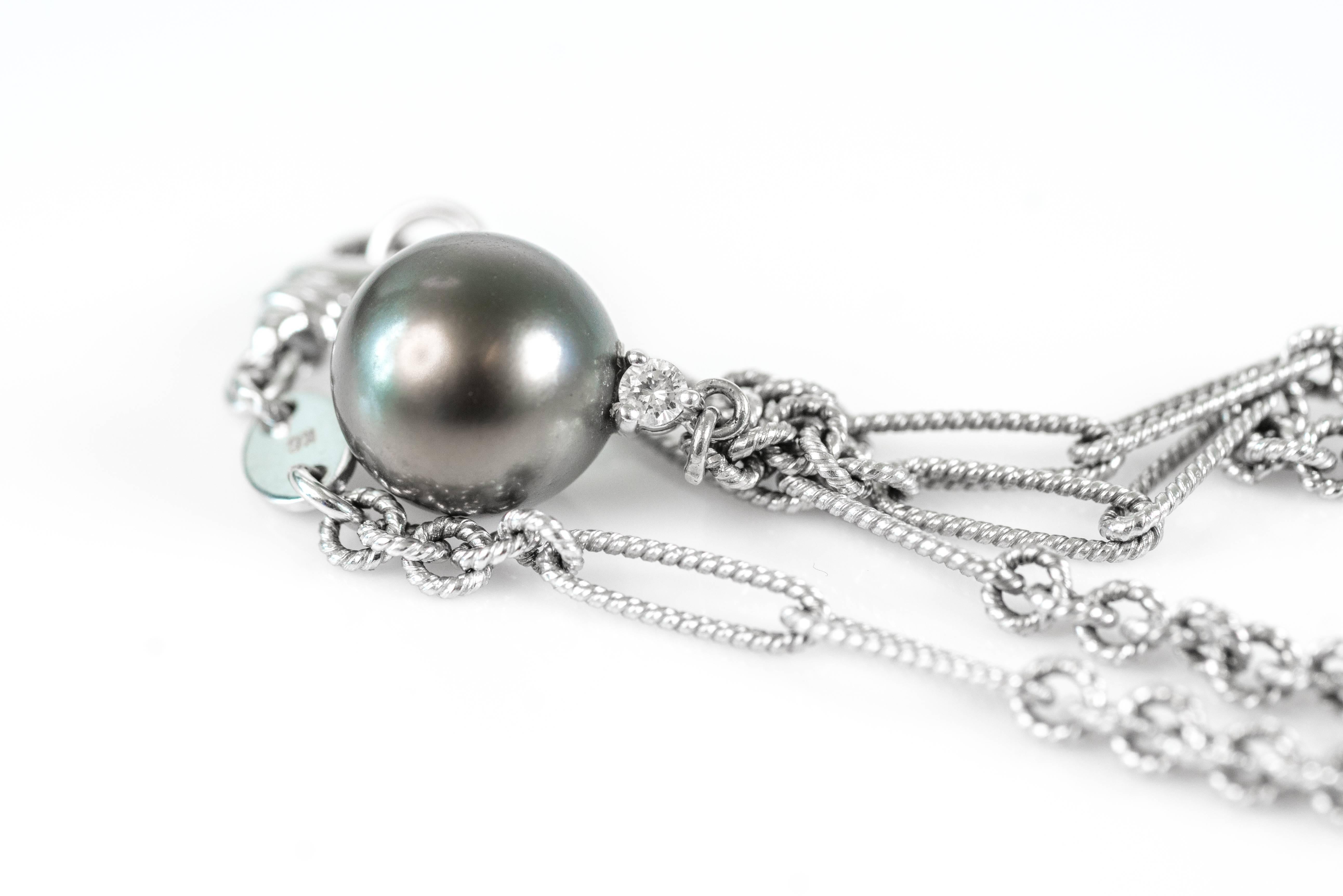 This 1990s Italian classic necklace features a grayish-green 11.5 millimeter Natural Tahitian South Sea Pearl accented by a .05 carat round brilliant diamond. The 18 karat white gold Figaro chain features links crafted in a braided weave pattern.