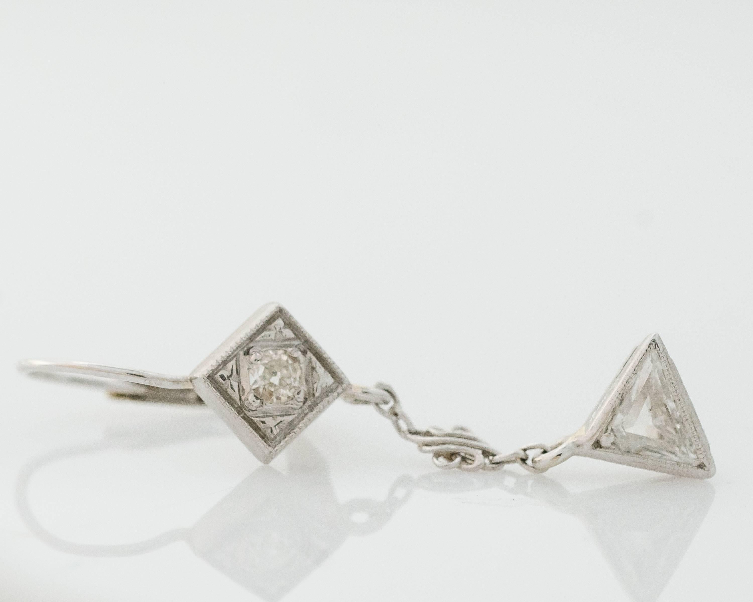 This pair of 1920s Art Deco Old Mine Diamond and 14 karat white Gold Earrings exemplifies excellence and attention to detail. Each earring features an Old Mine Brilliant Diamond in a diamond shaped setting at the top. 

Attached to this is a link of