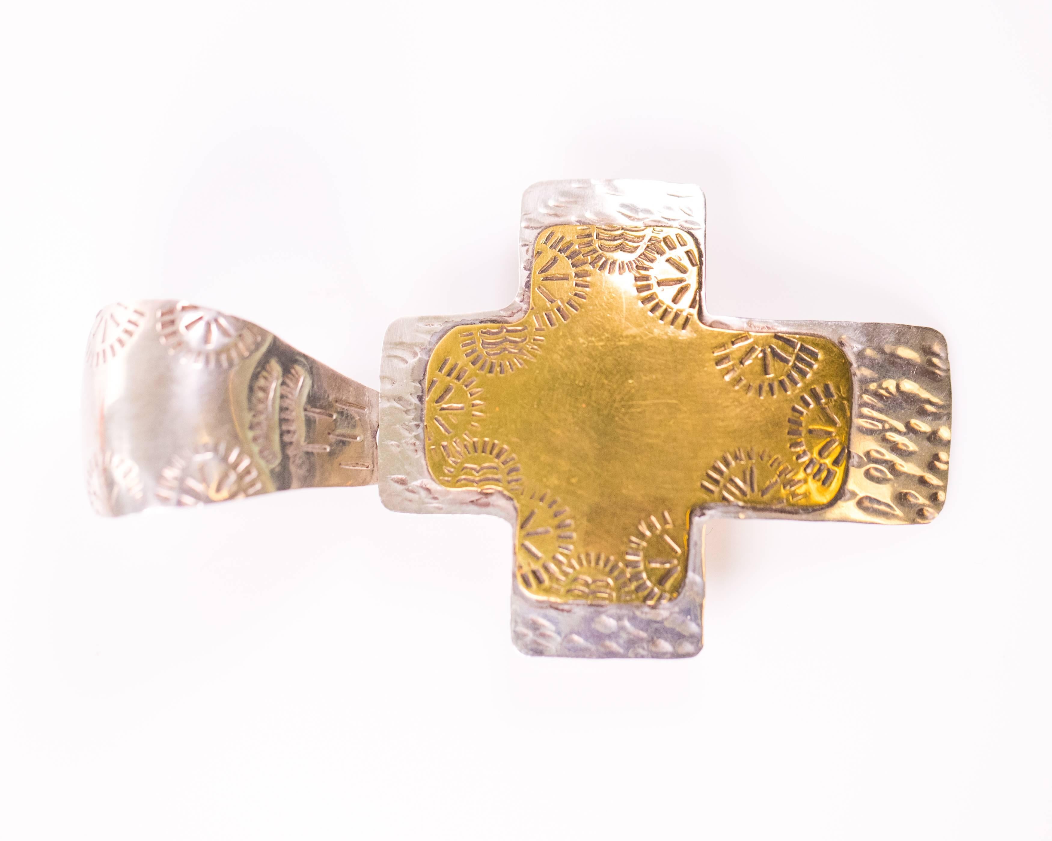 Handmade in Mexico, this gorgeous 1960s Cross Pendant is crafted from .925 Sterling Silver. It measures 3.5 inches high with the bail and 2 inches wide. It features a gold plate cross overlay in the center and native, indigenous-style pattern