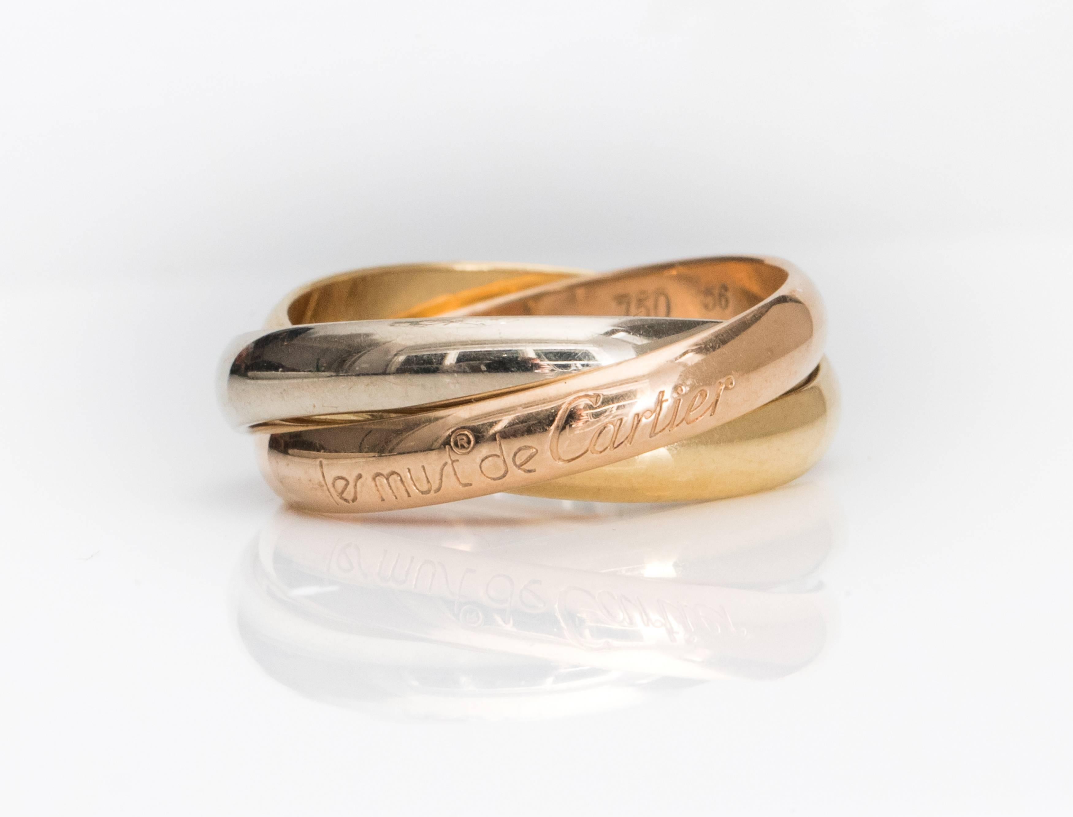 This 1980s Les Must De Cartier Trinity Band Rolling Ring is a Cartier Classic! It features 18 Karat White, Yellow and Rose Gold Bands interlocking in a Rolling Trinity Band design. Cartier chose each Gold Color for it's symbolism: Pink for Love,