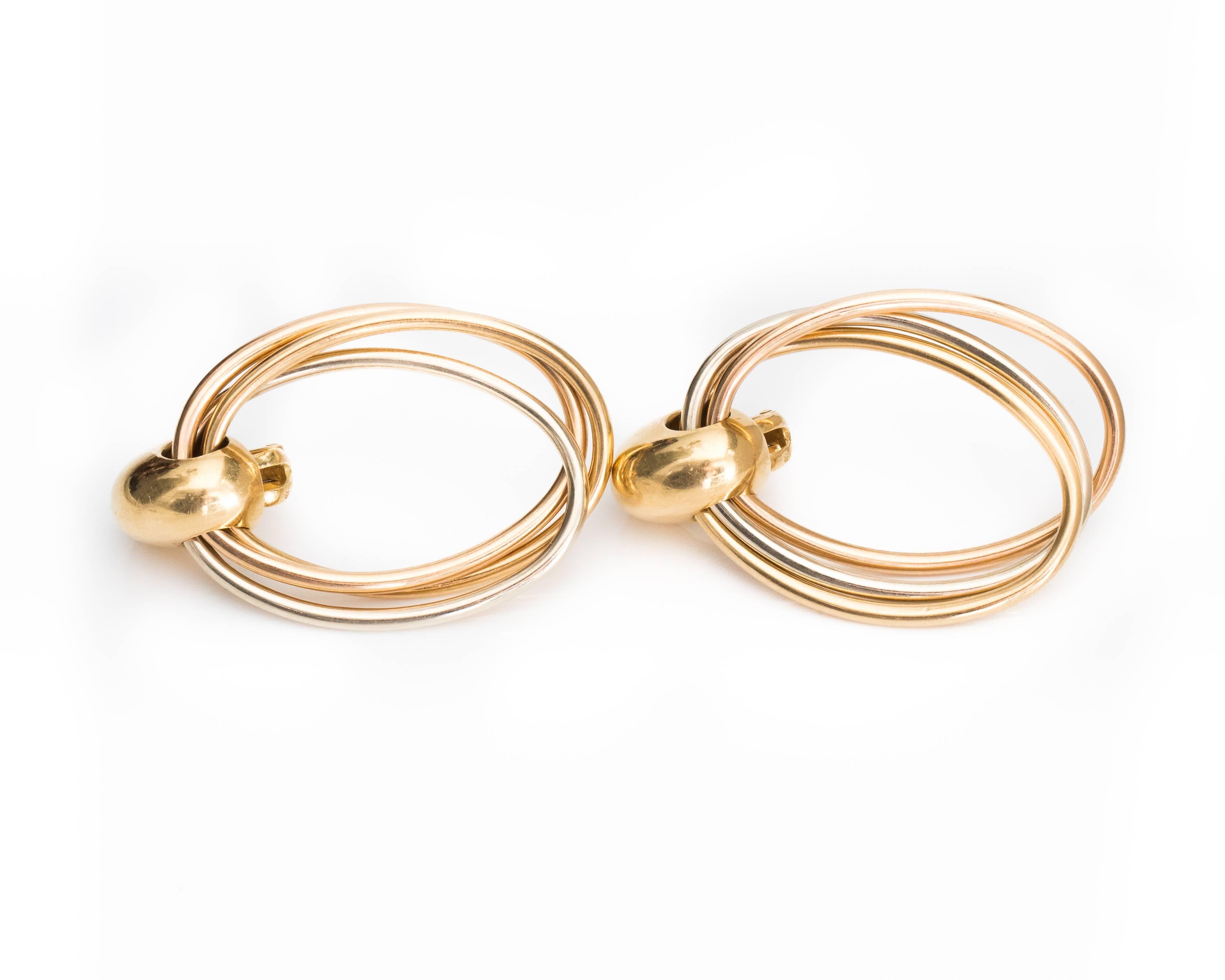 These Cartier Tricolor Earrings are an Everyday Classic! Each earring features a tricolor interlocking 18 Karat White, Yellow and Rose Gold hoop suspended from a bombe gold top. These gorgeous earrings are 1.75 inches long and have Posts with Omega