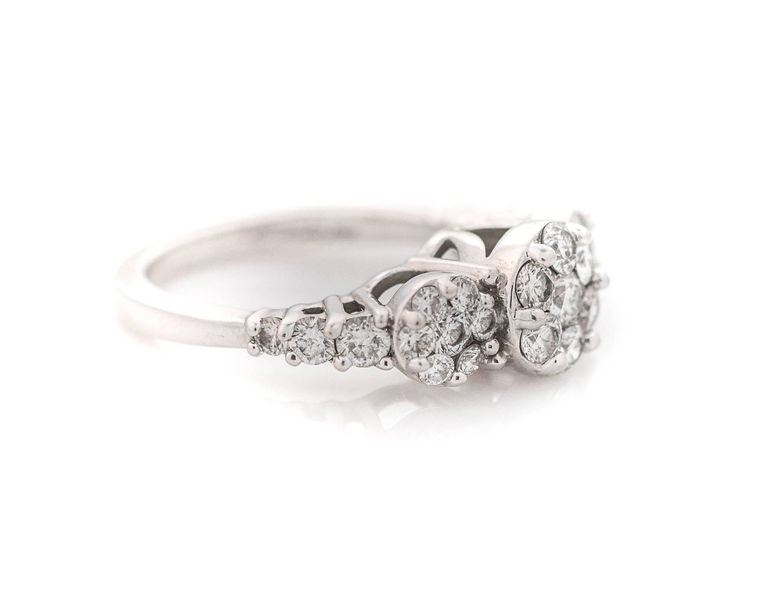 Questo bellissimo anello con diamanti a grappolo degli anni '80 è incredibilmente bello! Questo anello ha un peso totale di 1,00 carati di diamanti incastonati in oro bianco 14 carati. I diamanti sono disposti in un motivo floreale circolare al
