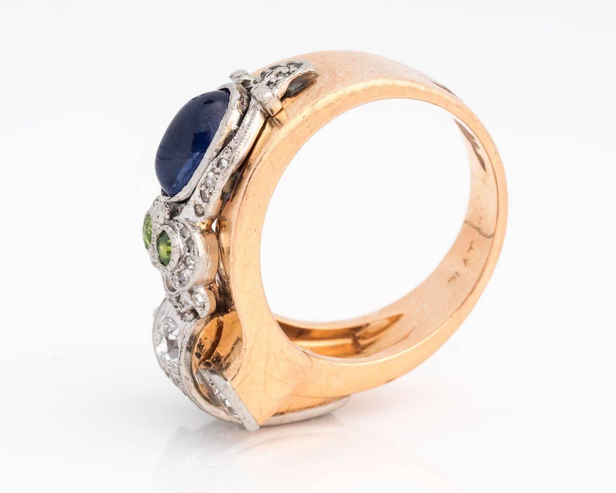 This intricate 14 karat rose gold and platinum ring is bursting with color and detail. The side of the ring has an owl-shaped figure, which is elevated above the ring band with platinum. Along the head and wings of the owl, there are single cut