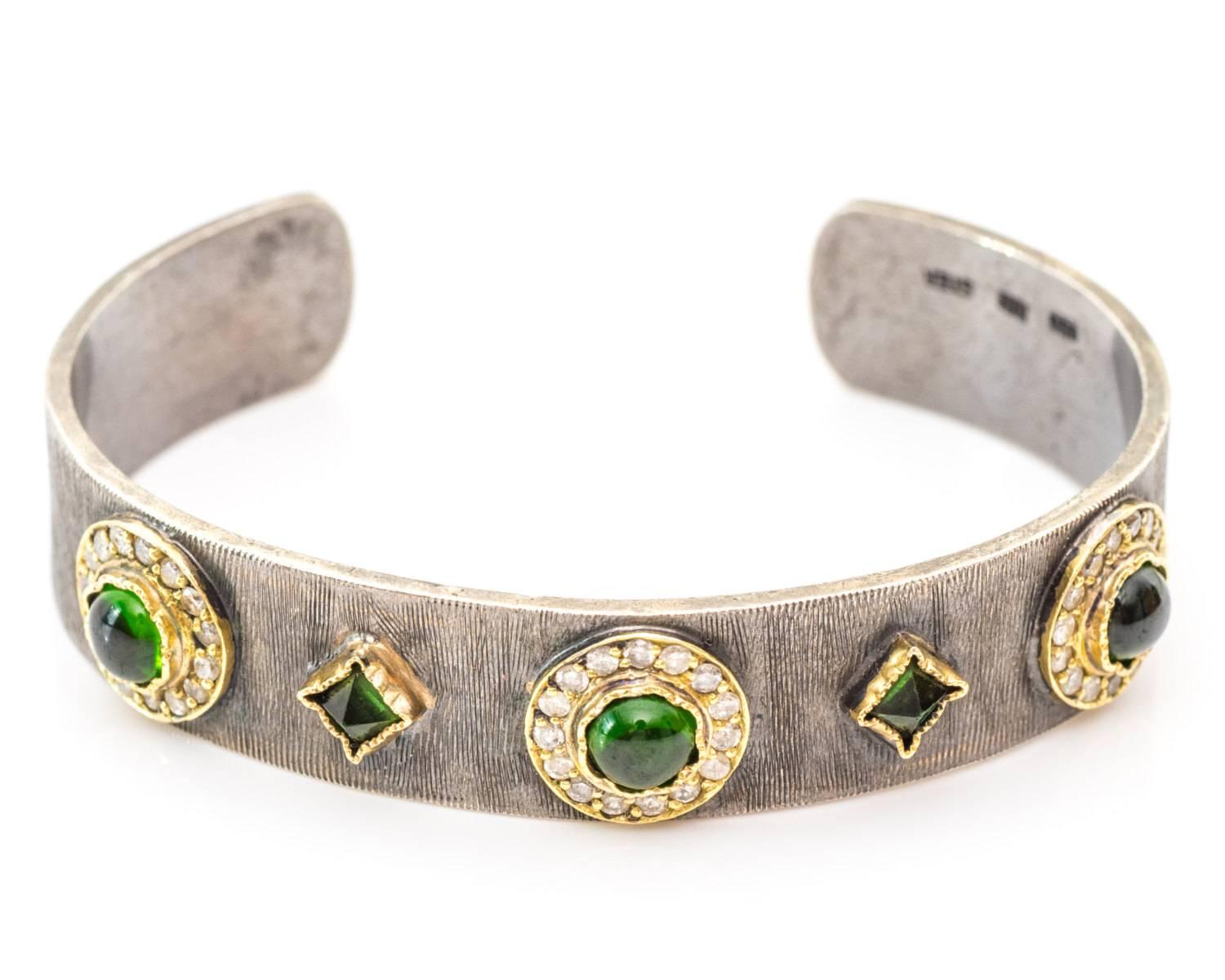 Beautiful Unique Cuff Bracelet made by Designer John Apel
Two-Tone Crafted in Sterling Silver and 18 Karat Yellow Gold
Adjustable, can Fit Most Wrist Sizes
Tsavorites and Diamonds

Diamond are all Bezel Set
Carat Weight: .75 carats
