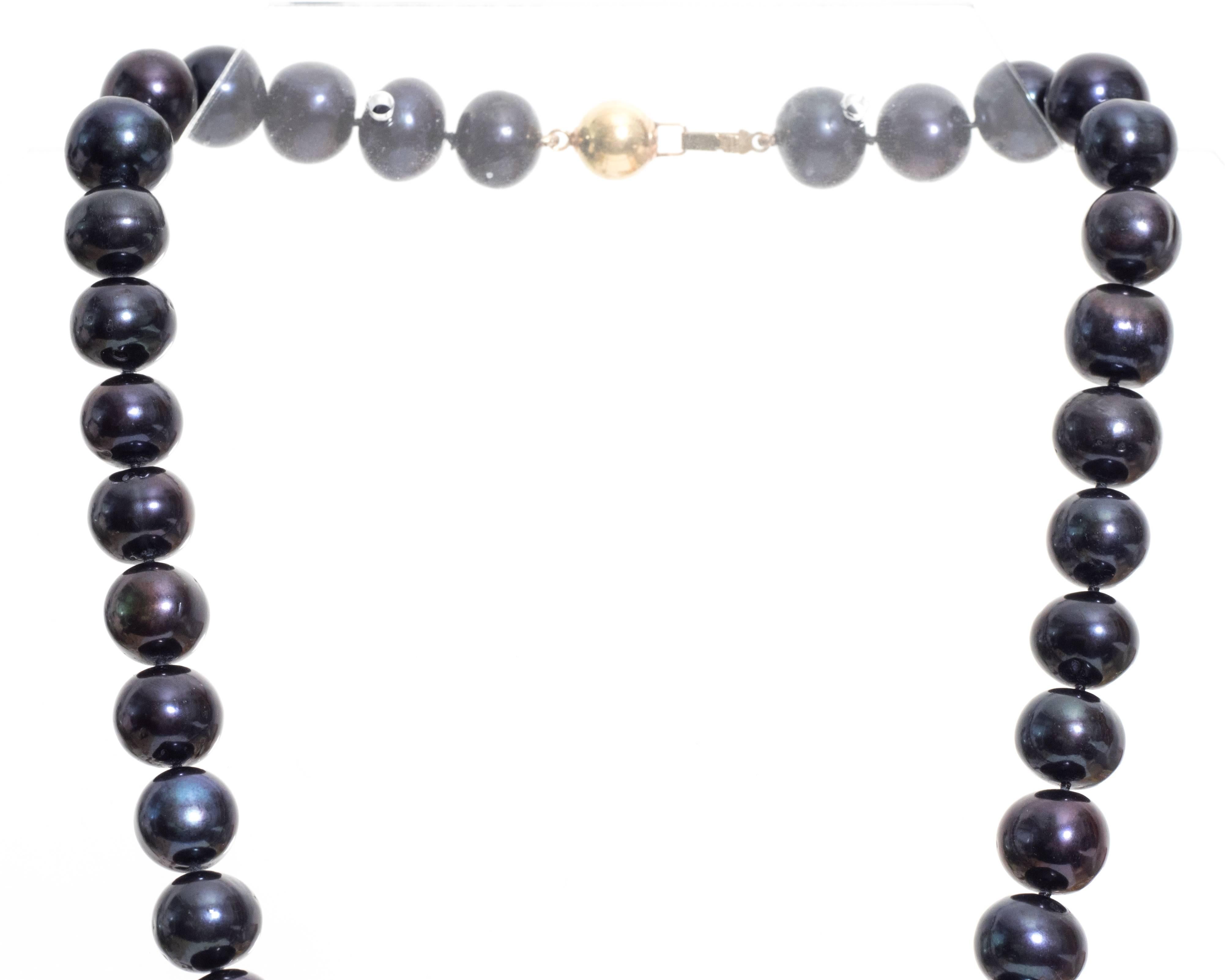 1980s Southsea Pearl Necklace
Each pearl is 11 millimeter in size with the same color and shape to every stone.
The clasp of the necklace has a large yellow gold bead attached to a standard back clasp. 
Hallmarked 14K on the back of the clasp.
 The