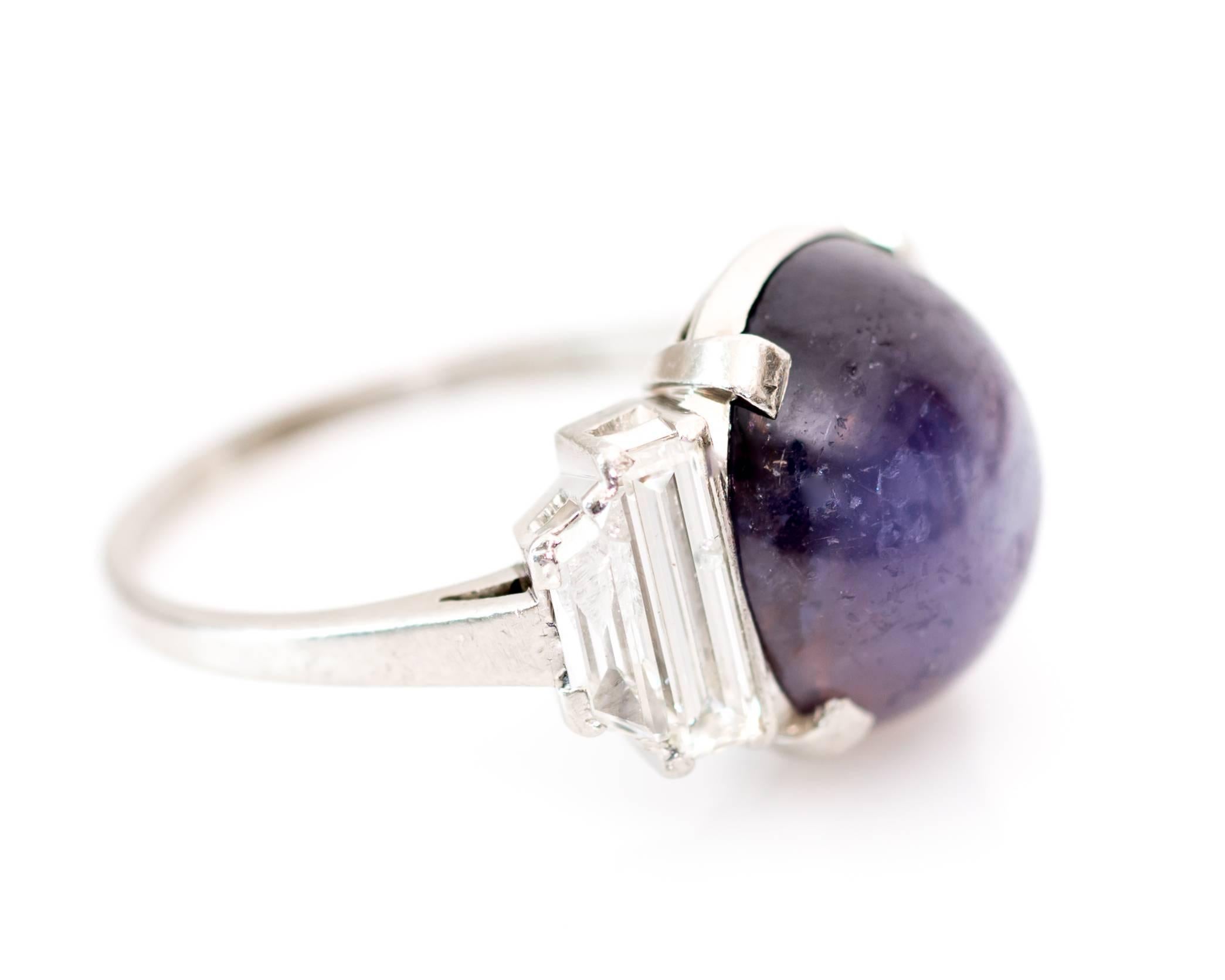 This stunning Star Sapphire Cabochon and Diamond Cocktail Ring is perfect for everyday wear! Baguette diamonds totaling .8 carats flank a prong set bluish-purplish 5 carat star sapphire cabochon which reveals a striking star radiating from the