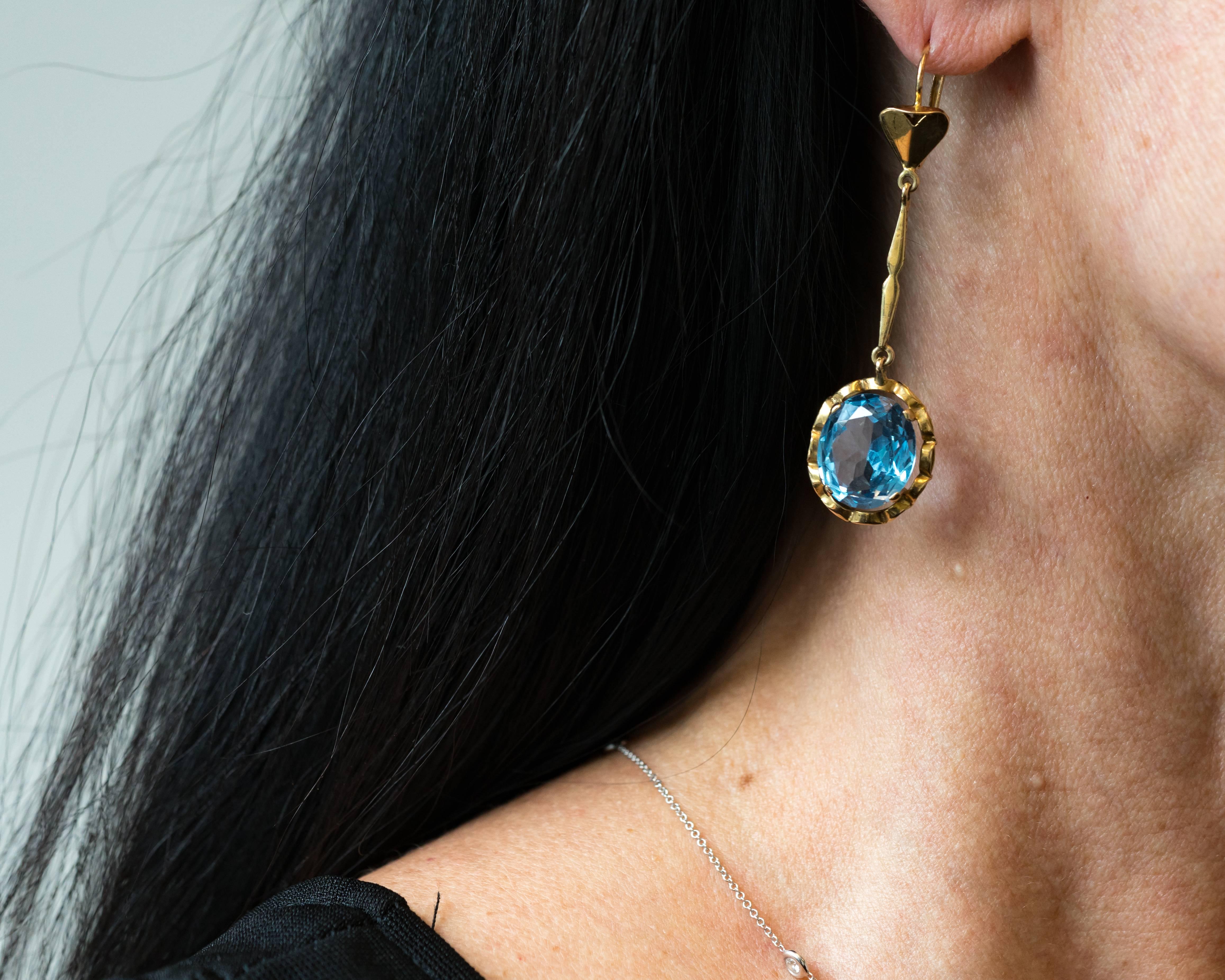We love these gorgeous Blue Topaz Dangle Earrings! Each earring features a 
prong set 5 carat blue topaz measuring 13 millimeters by 12 millimeters. The earring length measures 60 millimeters from the top of the wire arch to the bottom of the