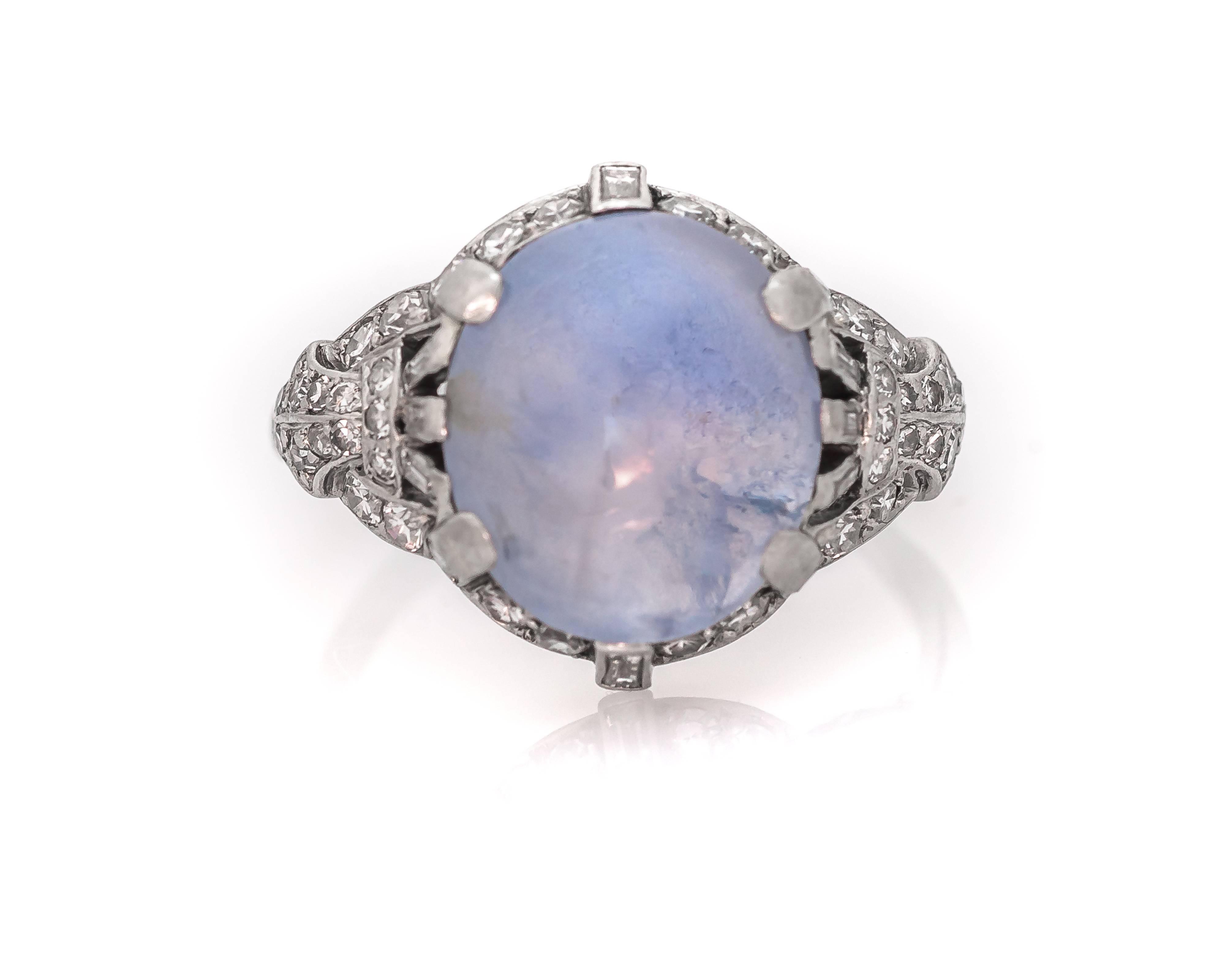 This 1930s 5 carat Star Sapphire and platinum ring was handmade by jeweler J. E. Caldwell and Co. The Sapphire is a beautiful translucent light blue and is prong-set with 6 larger prongs; two prongs feature an accent baguette diamond. Lovely