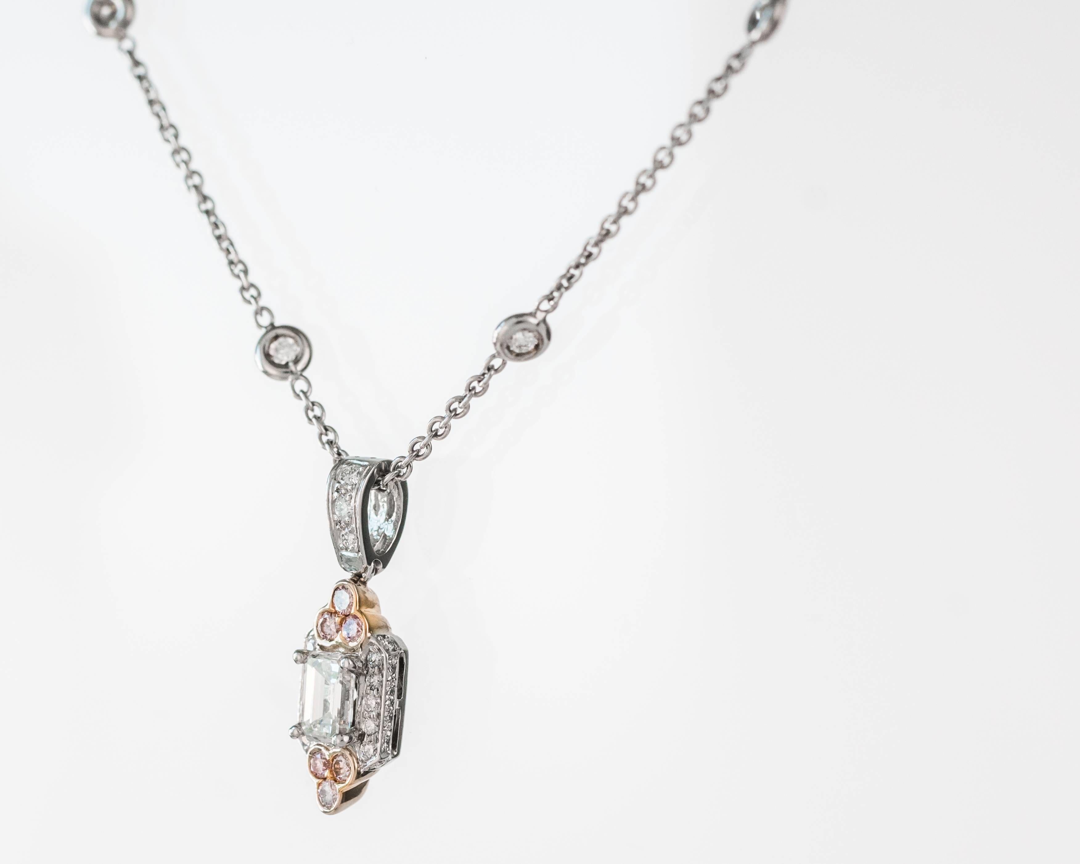 This Charles Krypell Diamond and Fancy Pink Diamond Necklace features diamonds set in Platinum and 18 Karat White Gold. The chain has 10 bezel set white diamonds. The pendant has a .5 carat emerald cut white center diamond  flanked by 10 prong set