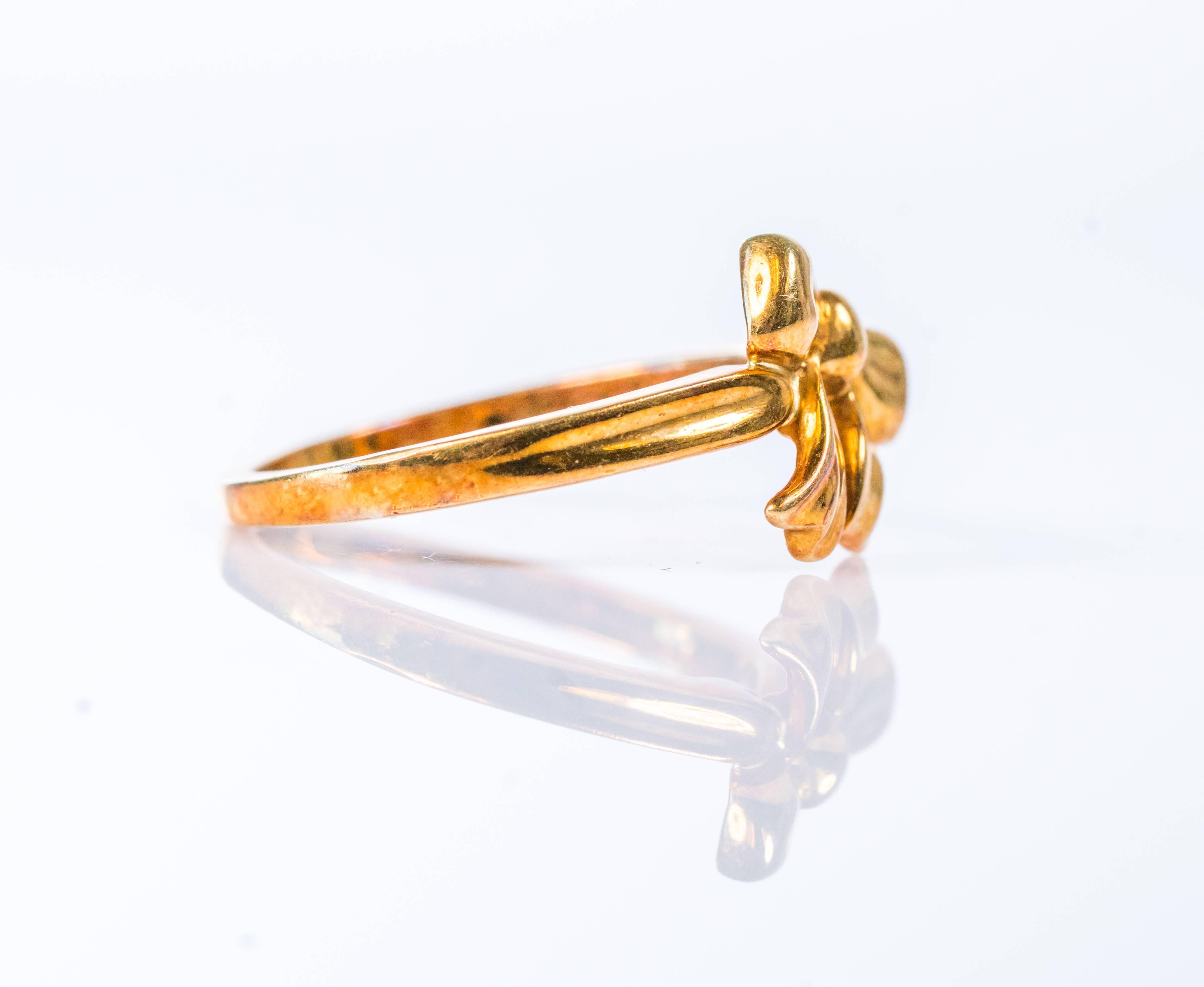 This 1980s Tiffany and Co. 18 karat yellow gold ribbon bow ring features 5.2 grams of 18 karat yellow gold. This ring is size 8.25 and can be resized. The inner shank is Hallmarked Tiffany & Co. 750. This sweet, feminine ring adds a dainty touch to