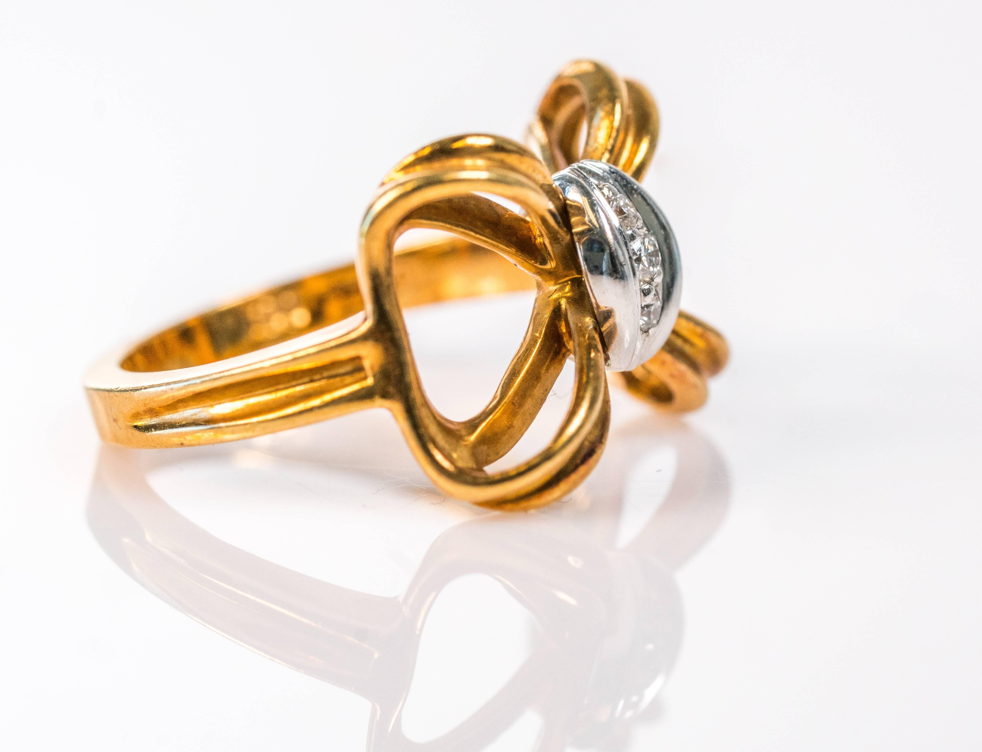 This 1980s Vintage Tiffany and Co. Bow Ring is made from 18 karat yellow gold. The center knot of the bow is made from platinum and is set with 3 round brilliant diamonds.  This ring is size 4.25. The inner shank is hallmarked Tiffany and Co. 750 PT