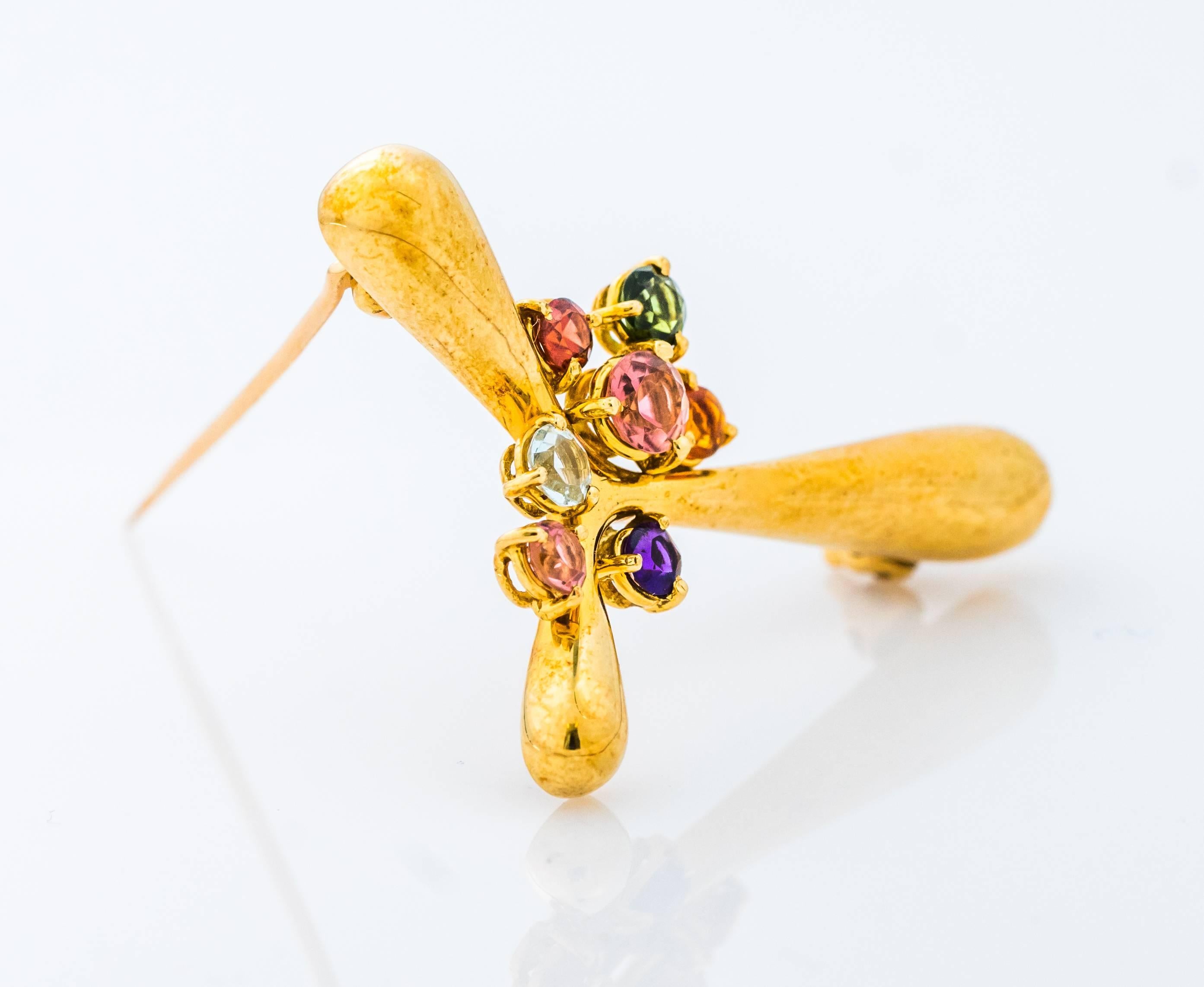 This lovely 1990s H. Stern 18 karat yellow gold brooch features 7 sparkling semiprecious gemstones including amethyst, tourmaline and aquamarine. This wonderfully abstract pin weighs 8 grams and measures 1.5 inches wide by 1.25 inches high. This