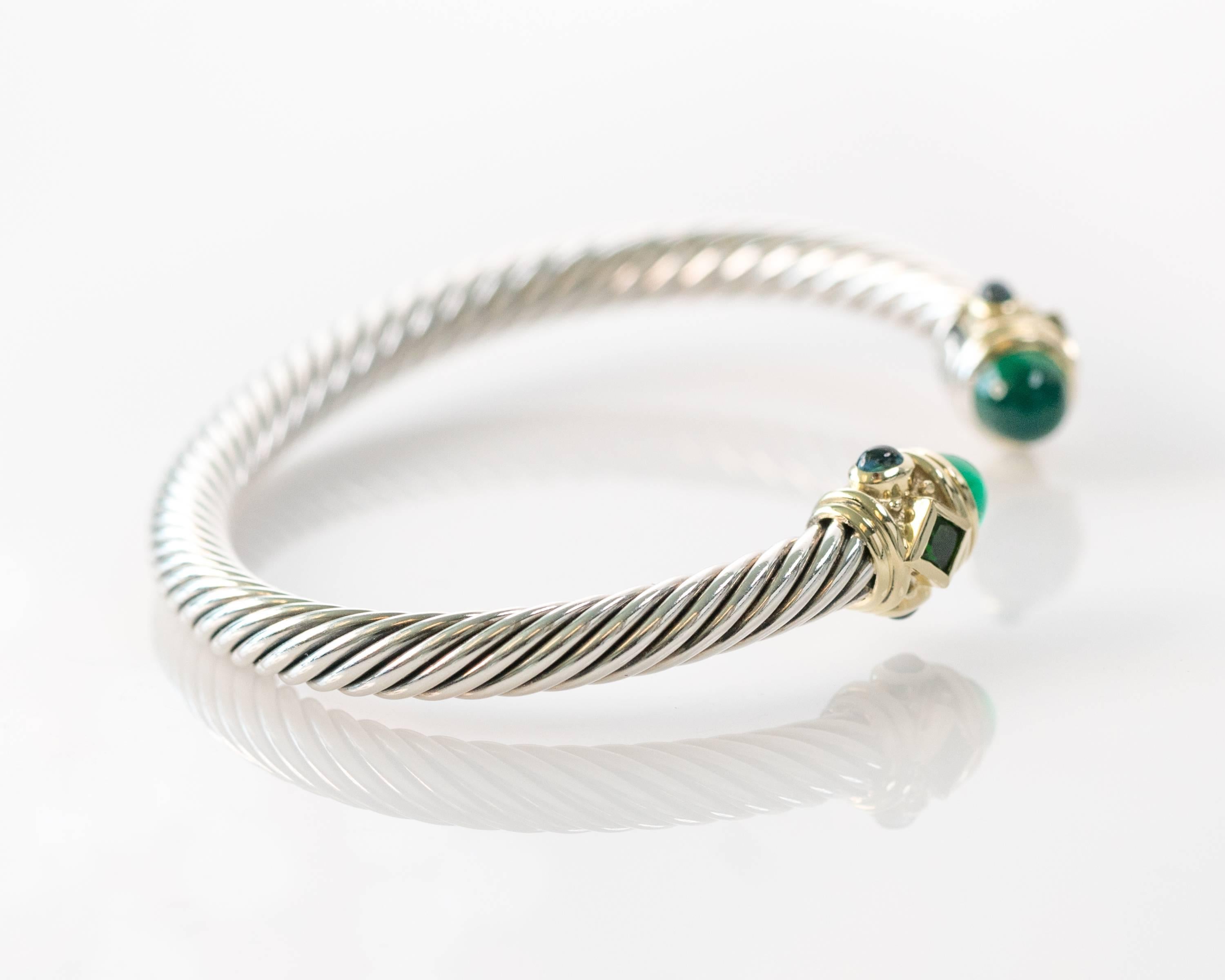 This Brand New, Unused, Unworn David Yurman Cable Collection Renaissance Bracelet is crafted from Sterling Silver and 14 Karat Yellow Gold. This handsome bracelet features 2 Chrome Diopside cabochons, 2 bezel set faceted Green Onyx and 4 bezel set