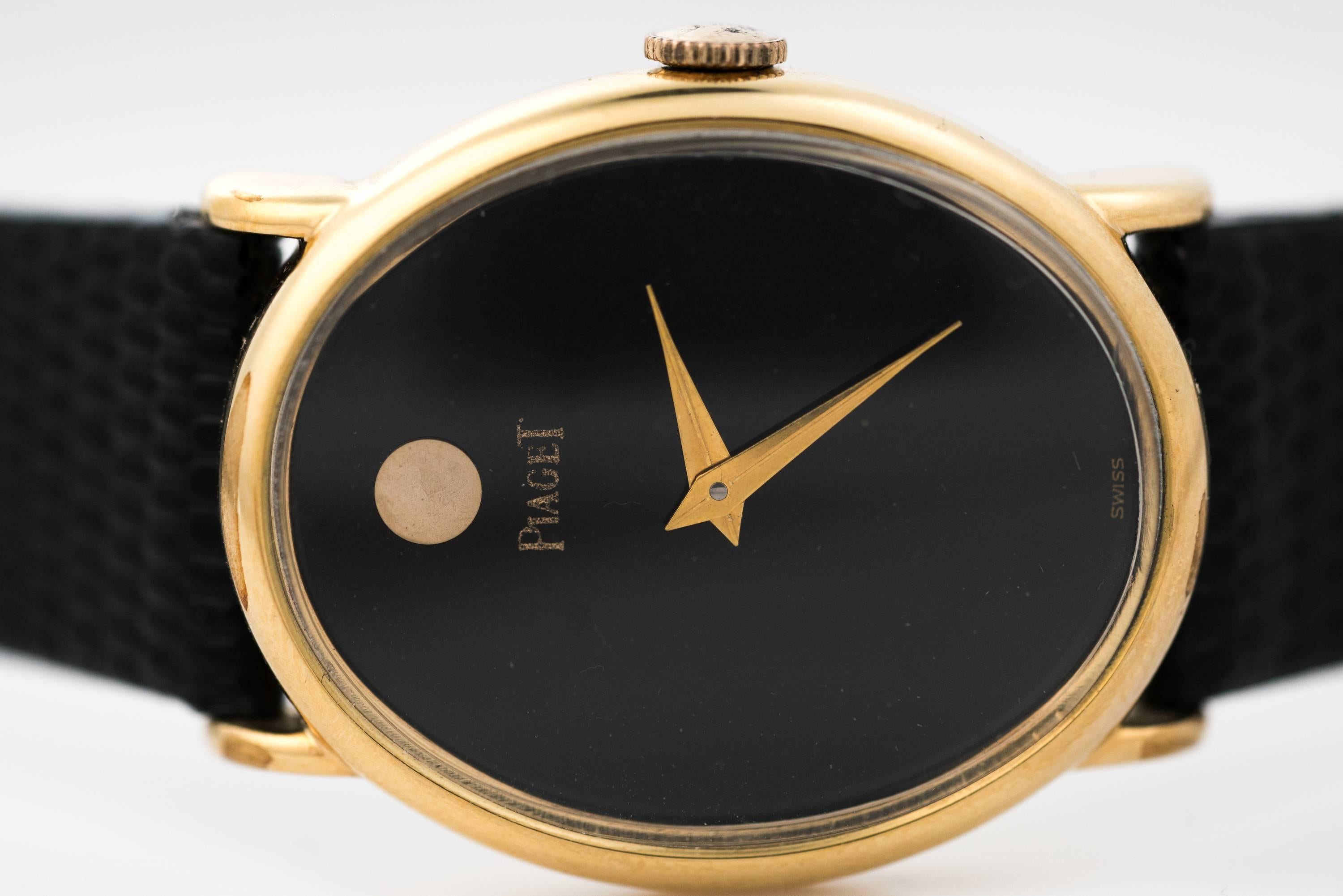 This lovely 1980s ladies Piaget oval wristwatch features classic styling, a black face, a plastic crystal, and a New black Leather Strap. The 18 karat yellow gold plate case measures 26 millimeters by 32 millimeters high. This manual wind watch was