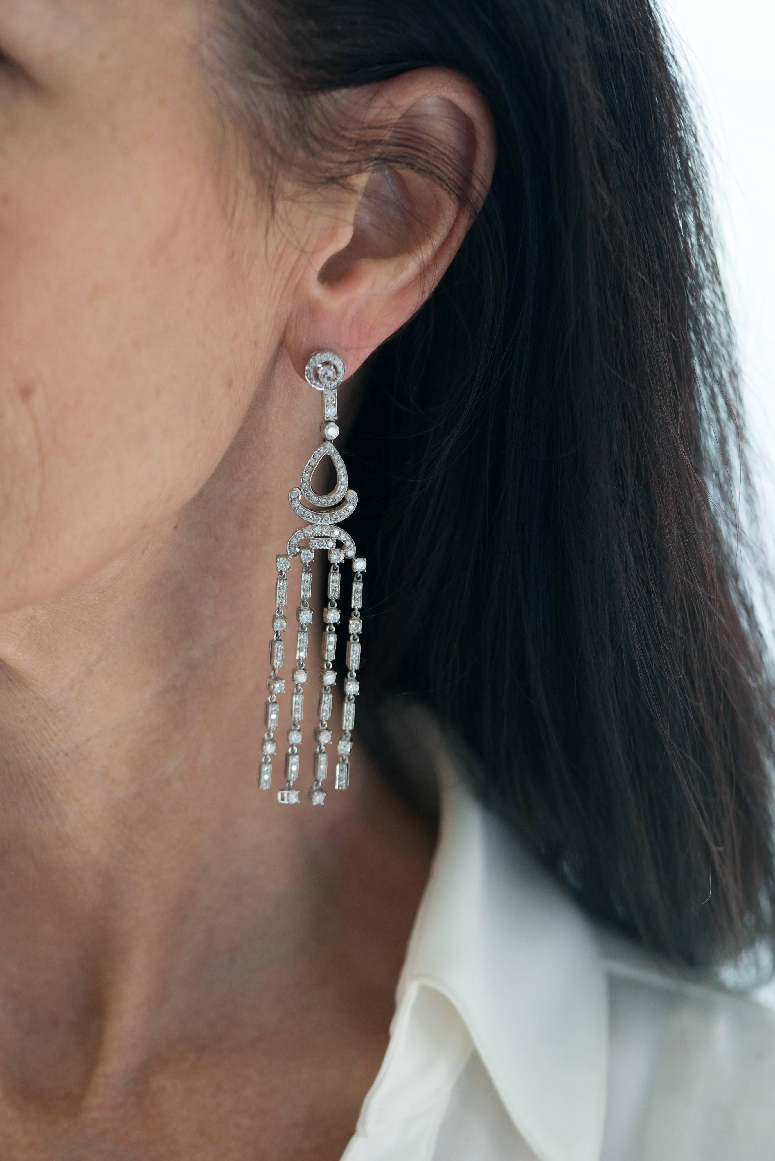 These Chandelier Earrings measure a long 3.5 inches and feature 6.3 carats of diamonds set in 18 karat white gold. The main body of each earring is hinged in 4 places and features 4 strands of diamond fringe, all combining to maximize the sparkle