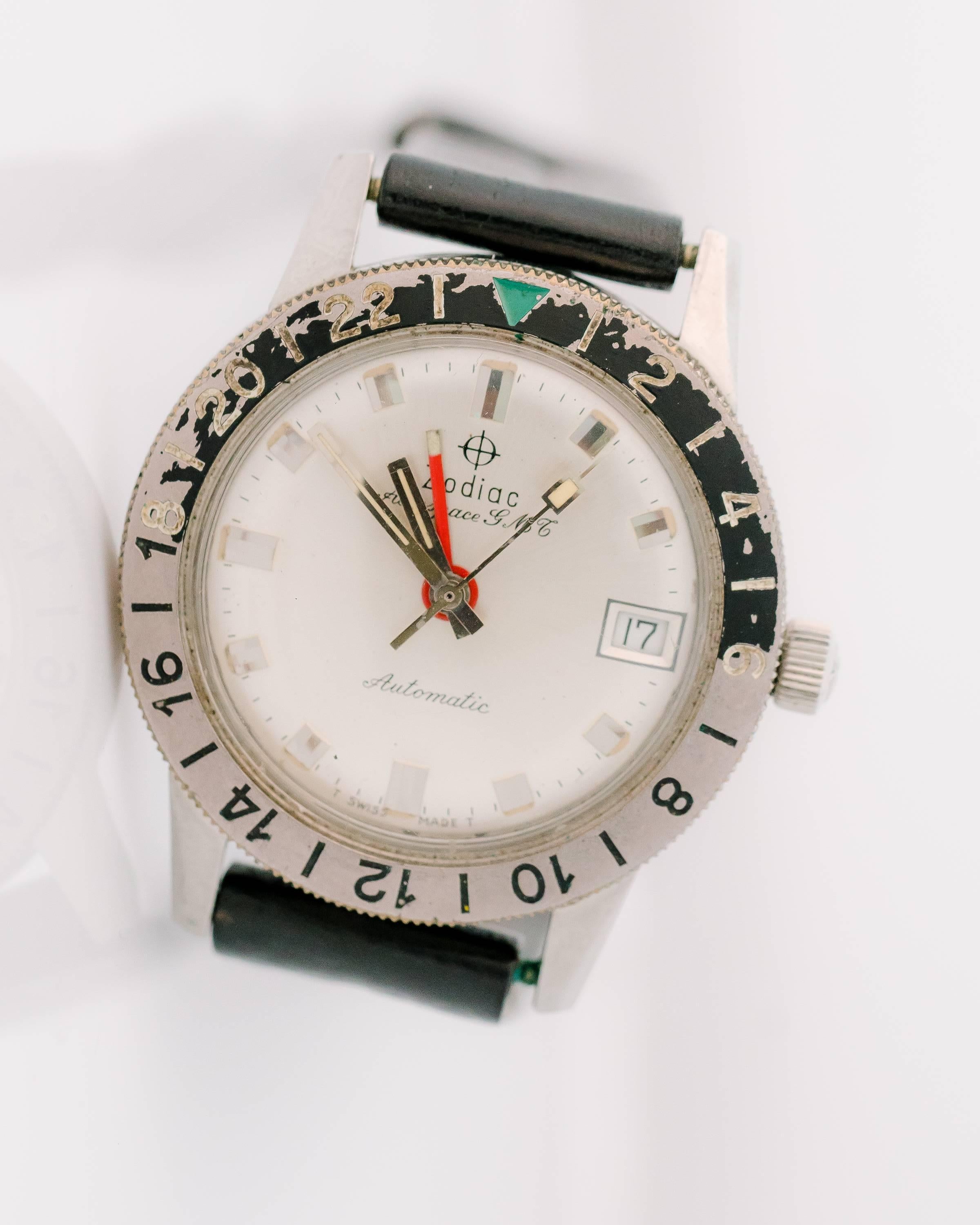 This 1950s Retro Zodiac Aerospace GMT Automatic Stainless Steel unisex wrist watch was designed with the world traveler in mind! The 24 hour black and grey rotating bezel has a green triangle 24 hour index. This allows the wearer to adjust for