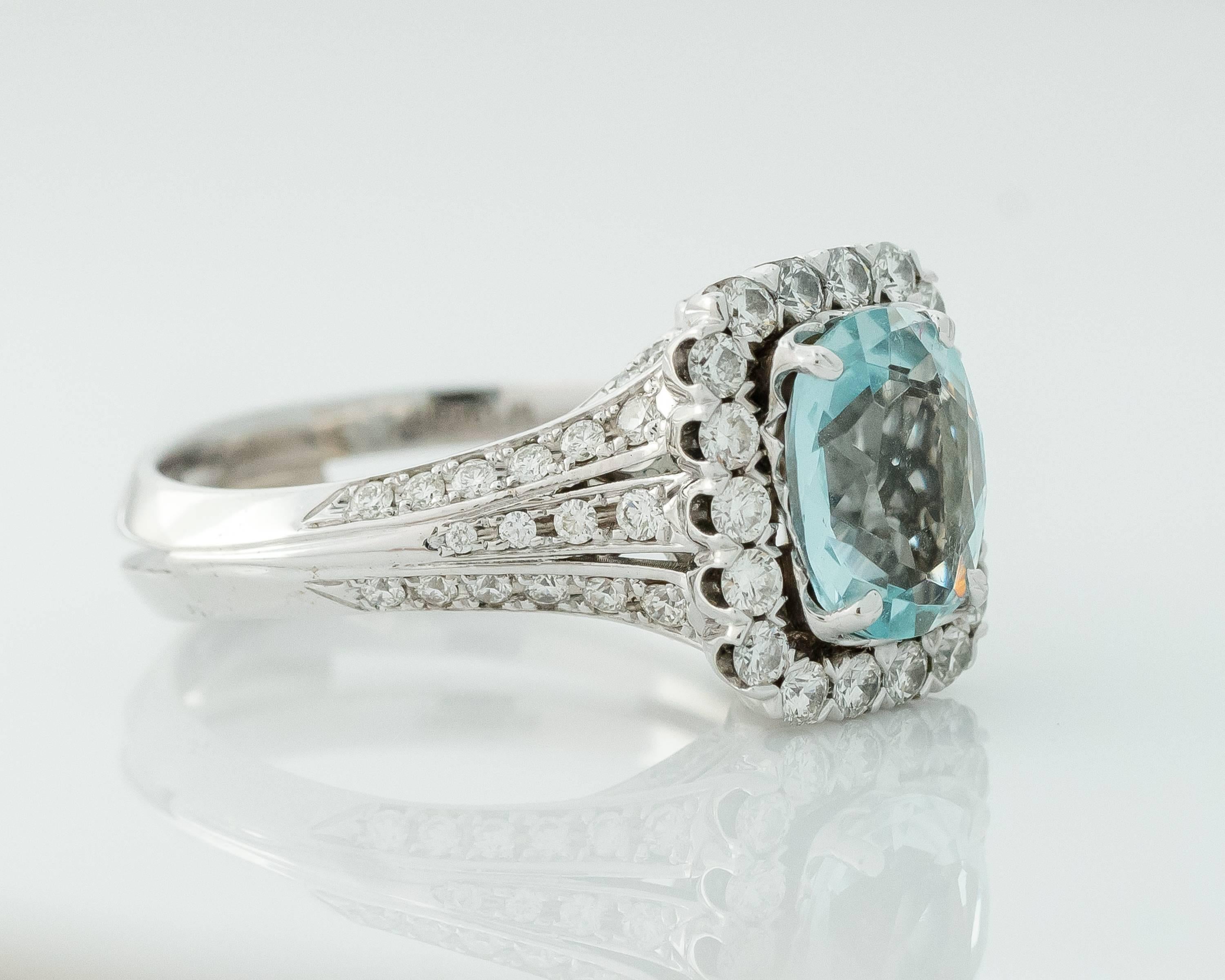  This gorgeous 1990s ring showcases a clear blue 3 Carat Aquamarine center stone surrounded by a beautiful Diamond Halo set in 14 Karat White Gold.

 The high cathedral mounting has a sweet diamond bow design on each of the 2 profile views. The