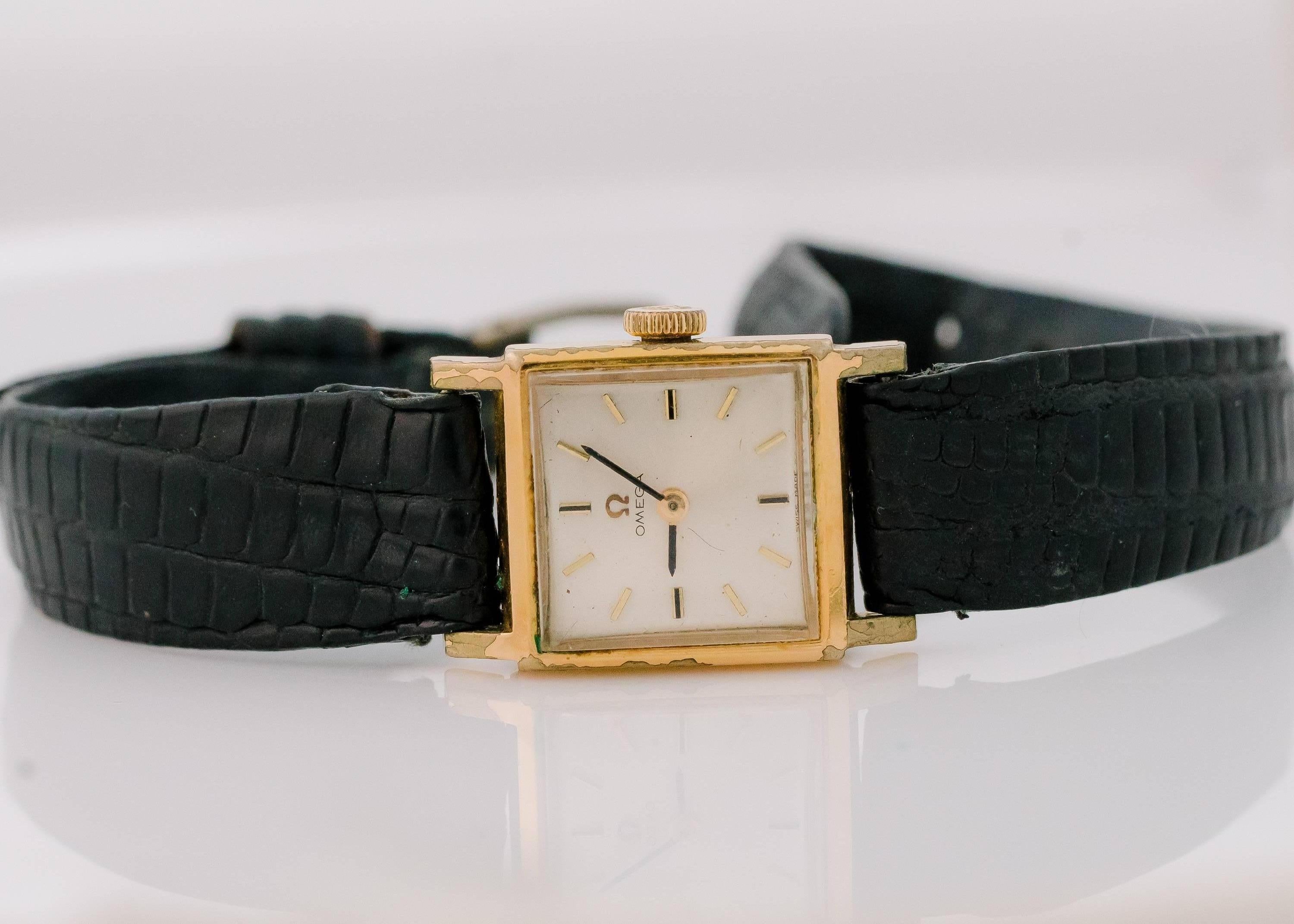 This 1950s Omega 14 Karat Yellow Gold Ladies Watch features a Square Tank style Case. This Swiss made watch has a stainless steel back, acrylic crystal, stick dial and leather strap. In true Retro style, it also has manual wind up movement. Wear