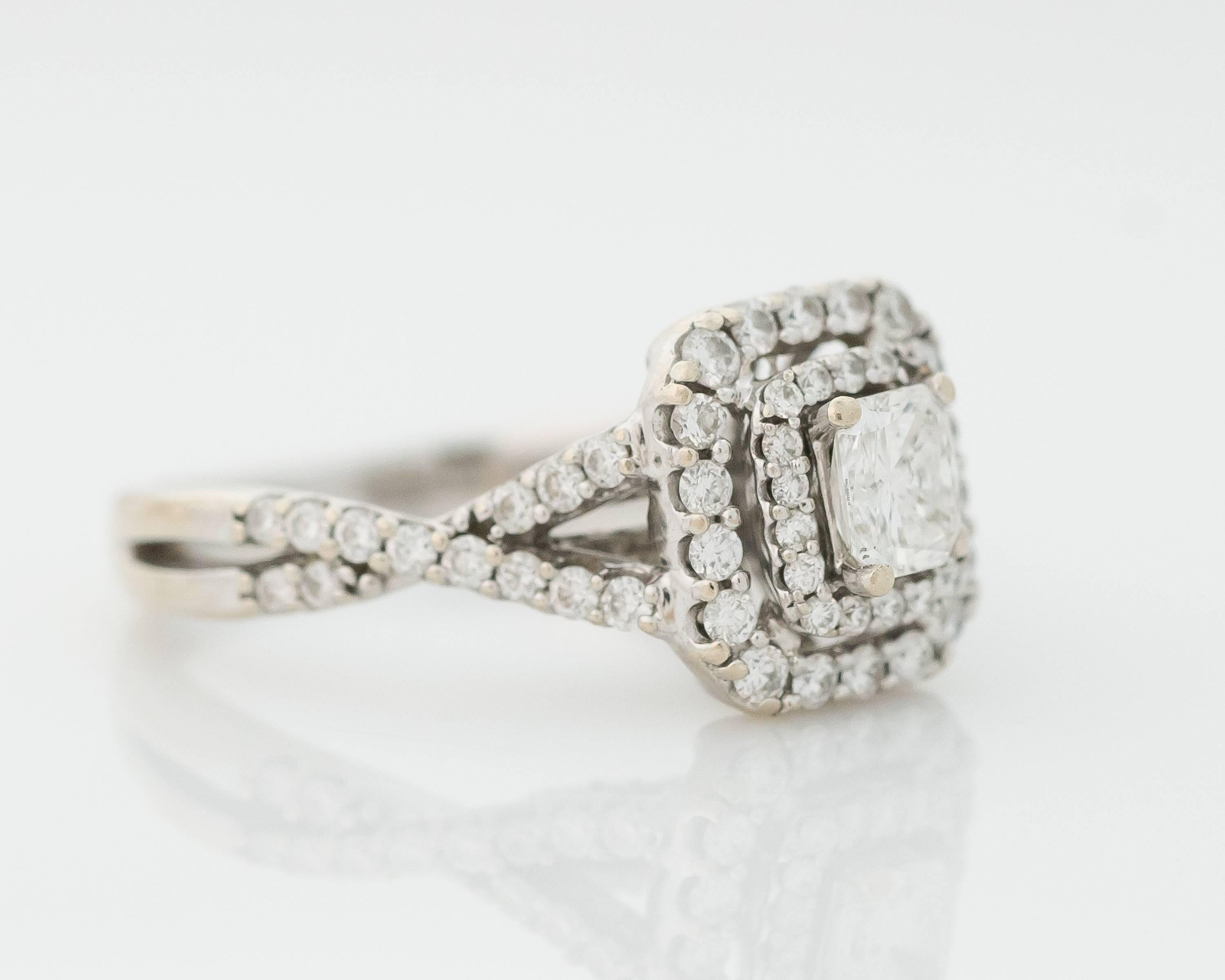  This stunning Diamond and 14 Karat White Gold Engagement Ring features 1 carat total weight of diamonds and a Double Halo cathedral setting. Diamonds Everywhere! 
The criss-cross split shank has a smooth back half for wearing comfort while the