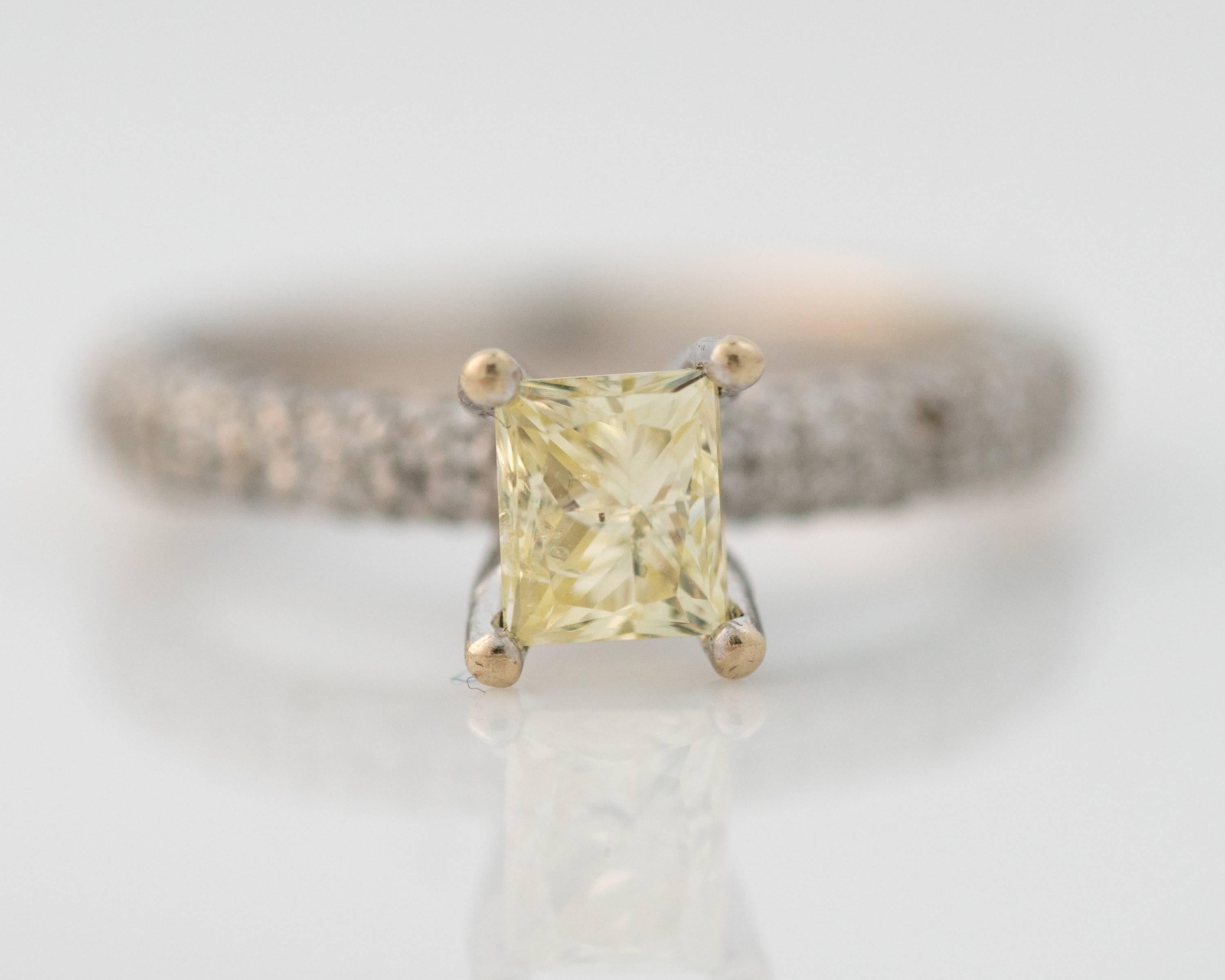 This beautiful Fancy Yellow Diamond Solitaire Engagement Ring is sure to please! Featuring a 1 carat Fancy Yellow center Diamond flanked by .25 carats total weight of round brilliant diamonds set in 14 karat white gold, this stunning ring will fit a